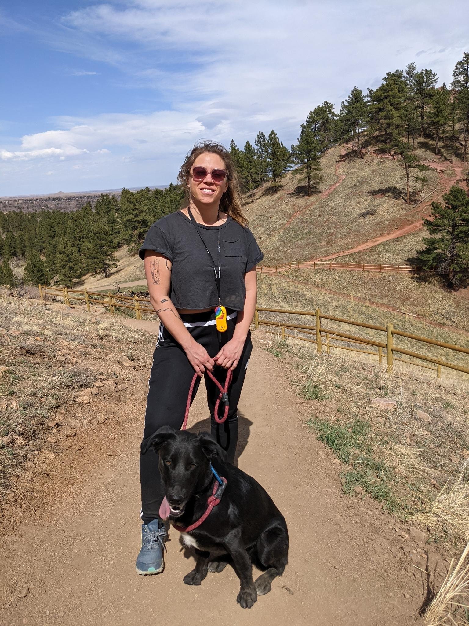 woman with black dog on hiking trail