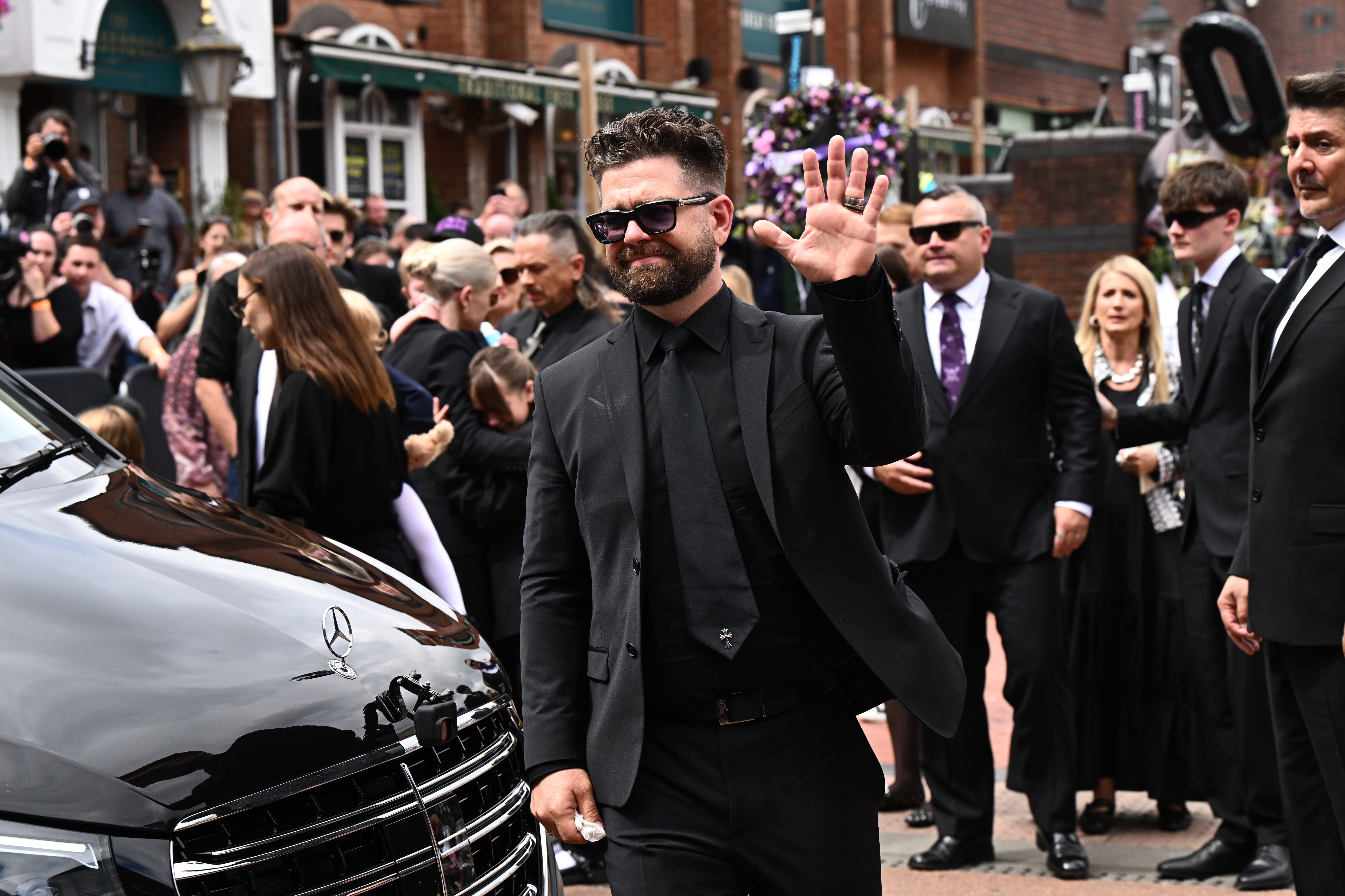 Jack Osbourne holding up a peace sign.