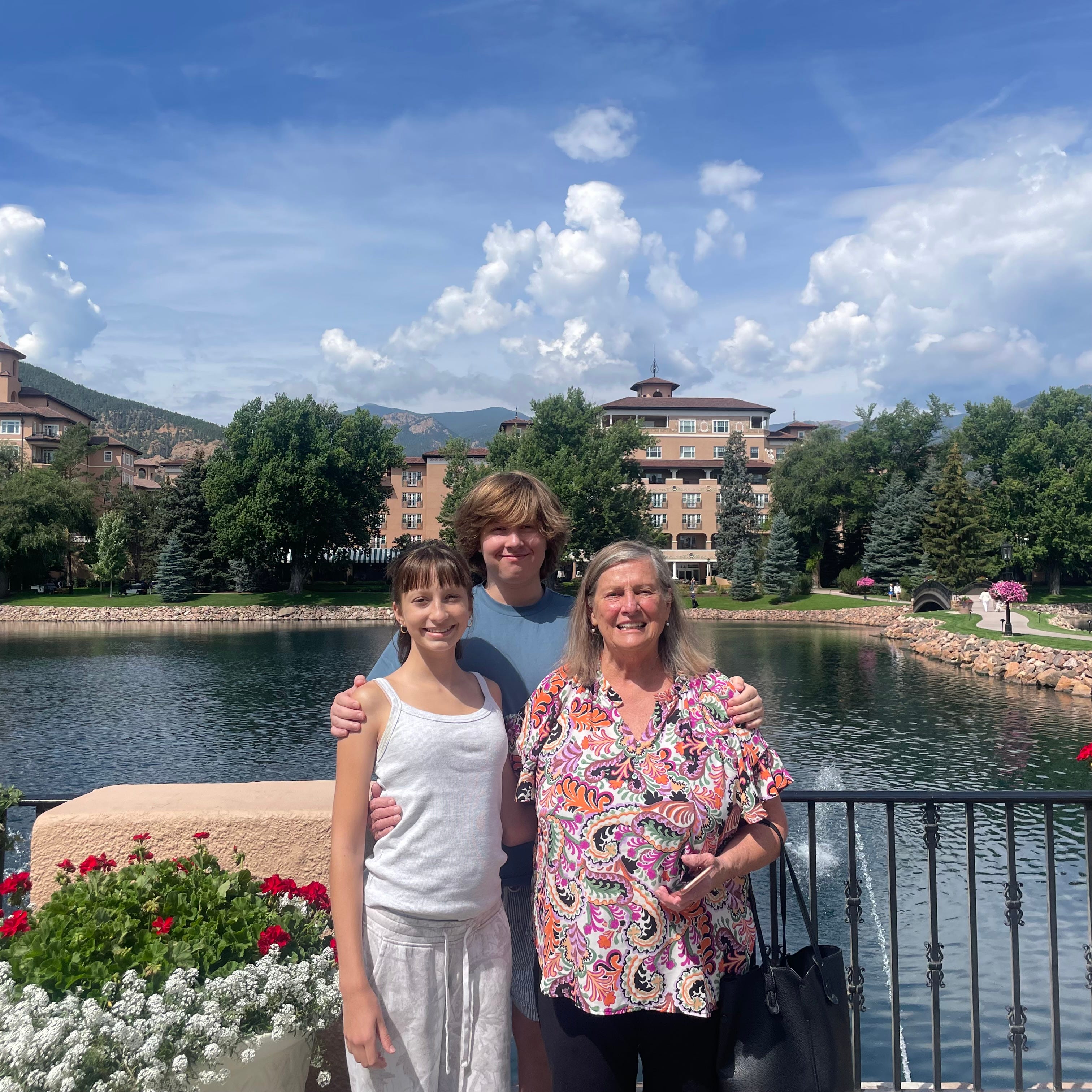 Teenage boy, tween girl, and older woman smiling together