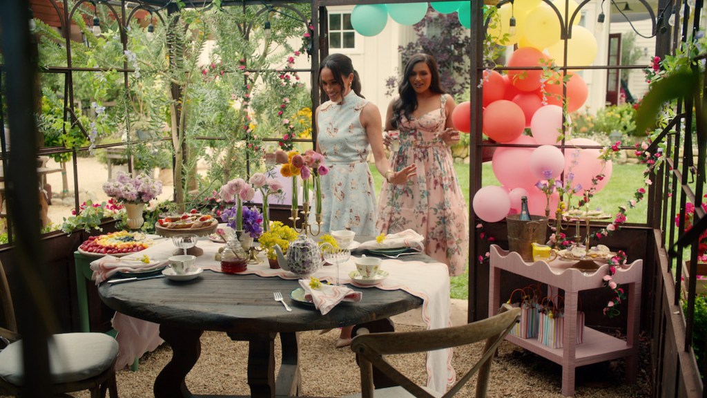 Meghan Markle in a light blue floral dress with Mindy Kaling in a pink floral dress.