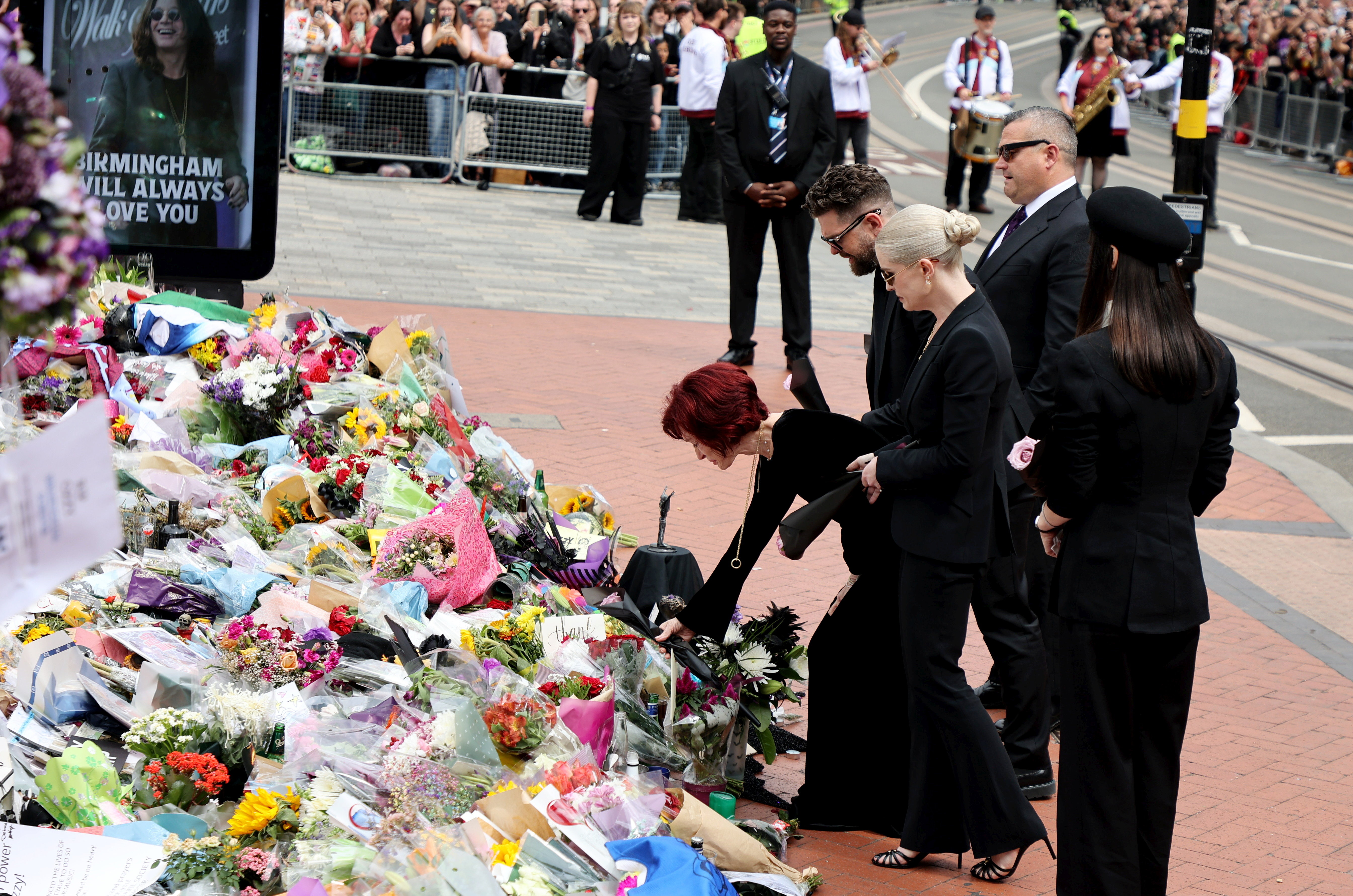 Kelly, Jack, Aimee, and Sharon Osbourne place flowers at Ozzy's funeral in Birmingham, England.