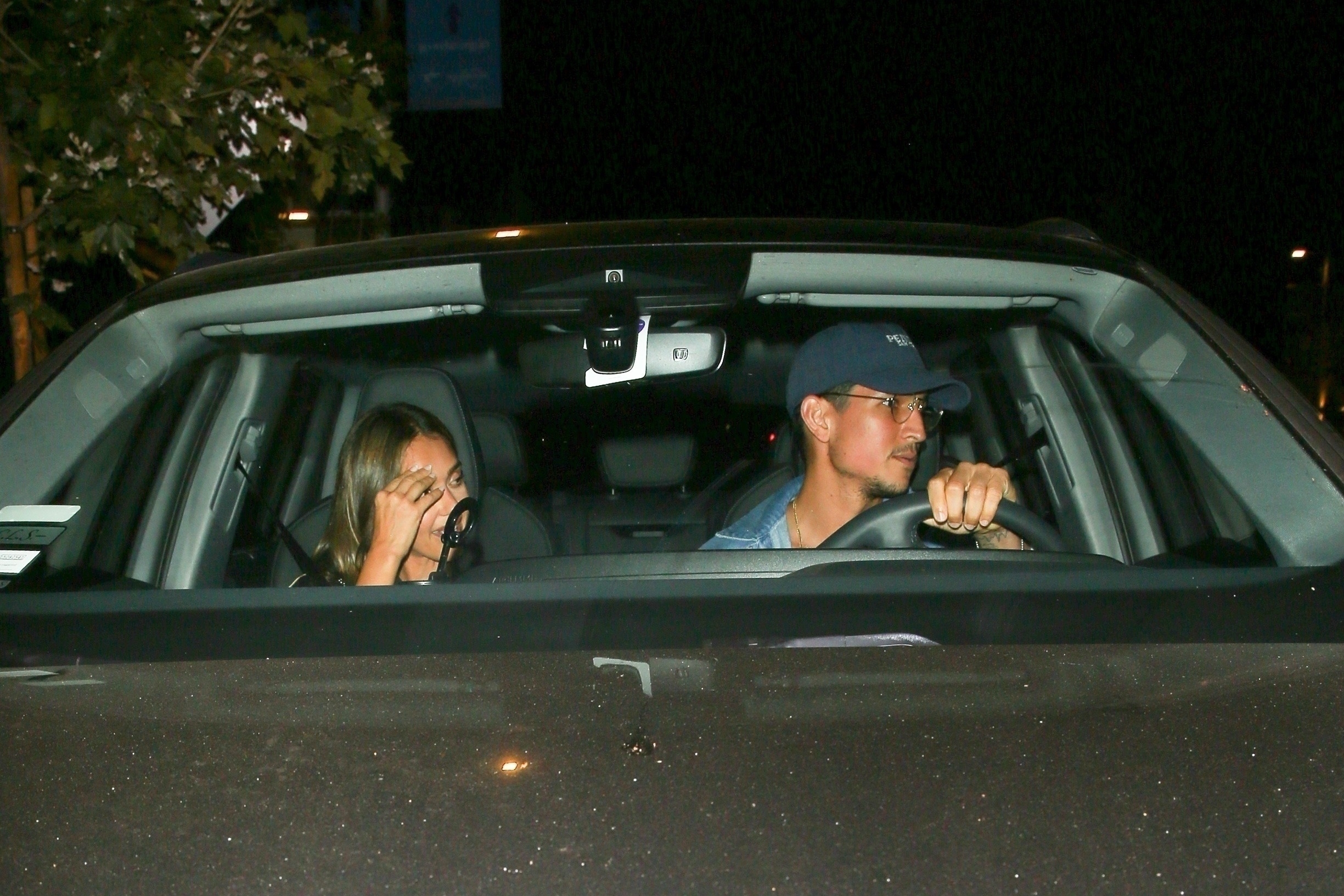 Jessica Alba and Danny Ramirez in a car at night. 