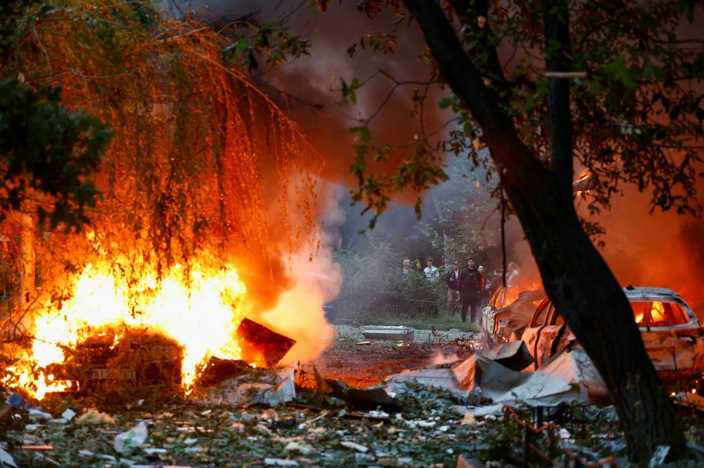 People watch a blaze from a Russian missile struck in Kyiv, Ukraine on July 31, 2025. 