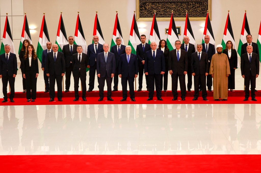 Palestinian Authority President Mahmud Abbas poses for a picture with new Palestinian government, after it was sworn in on March 31, 2024, in Ramallah, in the occupied West Bank.