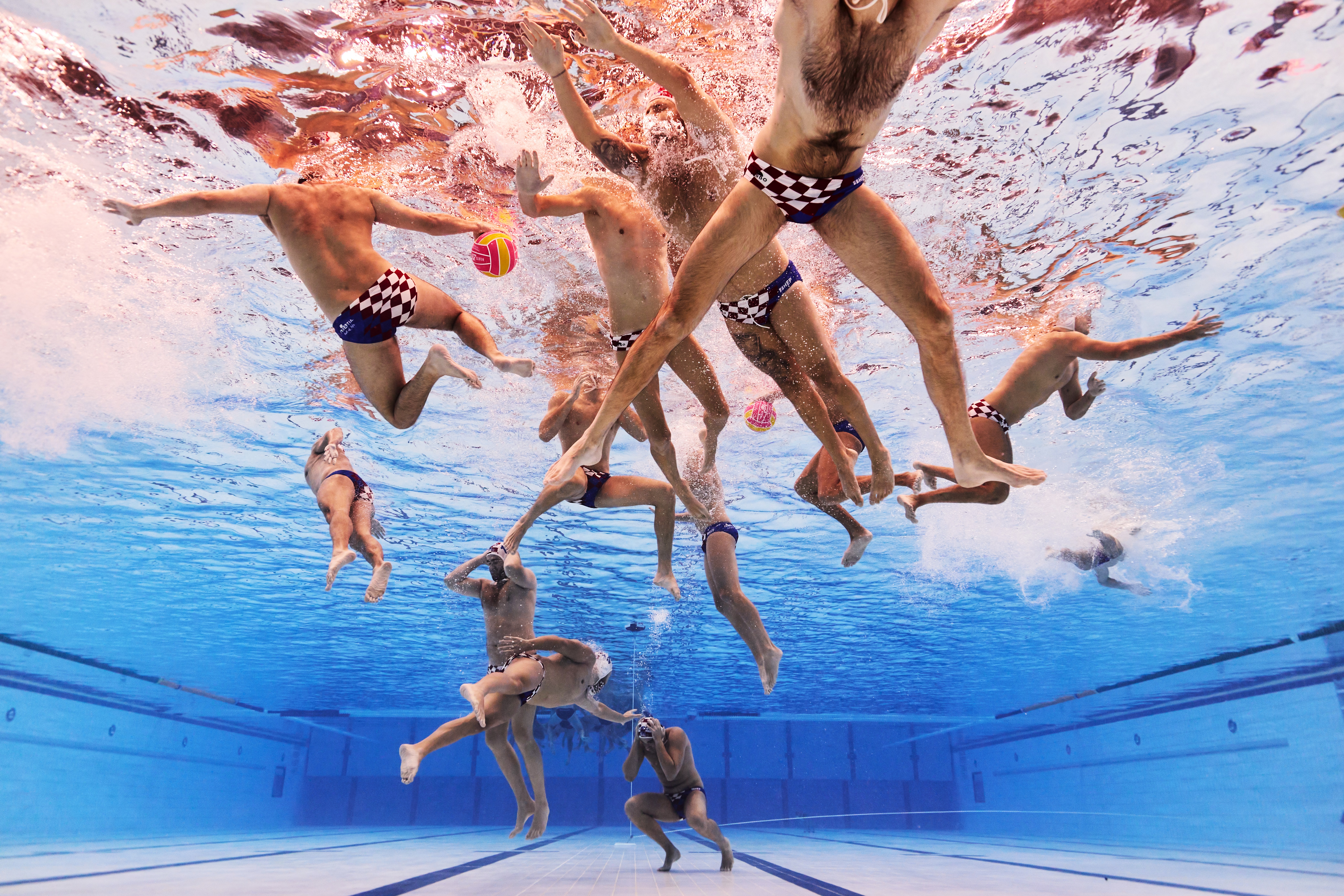 An underwater view of a water polo team getting ready for a match.