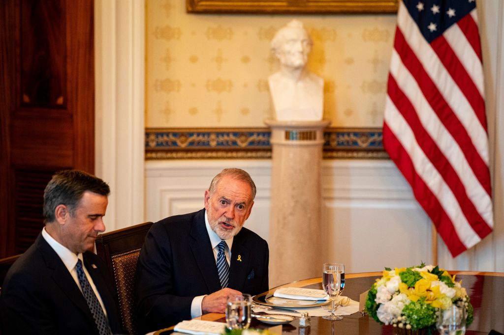 John Ratcliffe and another man seated at a table in the White House.
