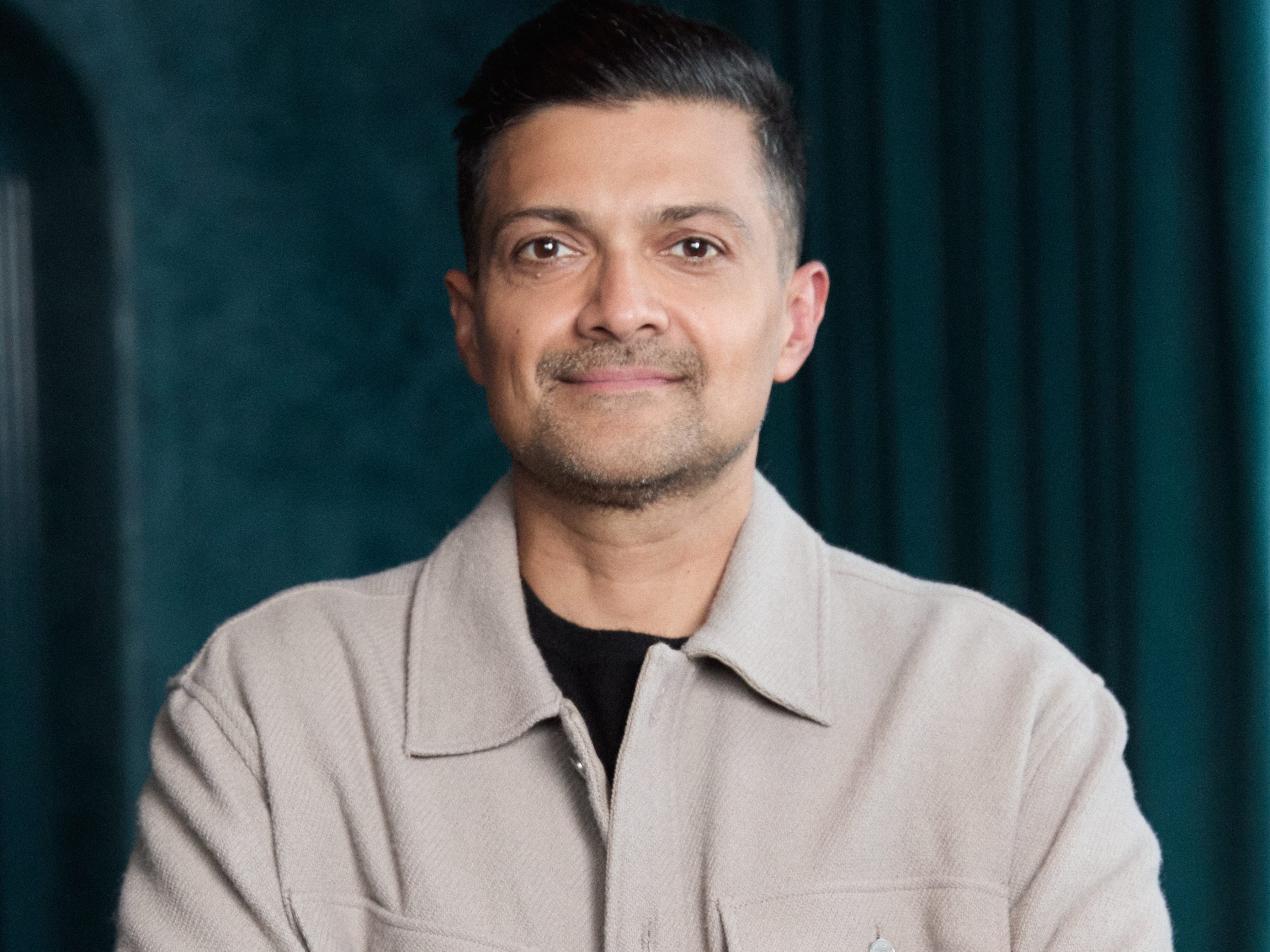 Mamoon Hamid, crossing his arms and wearing a khaki button-up shirt.