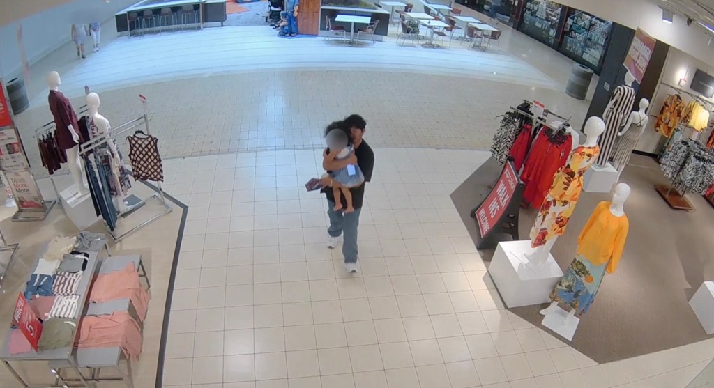 Surveillance image of a man abducting a toddler in a shopping mall.