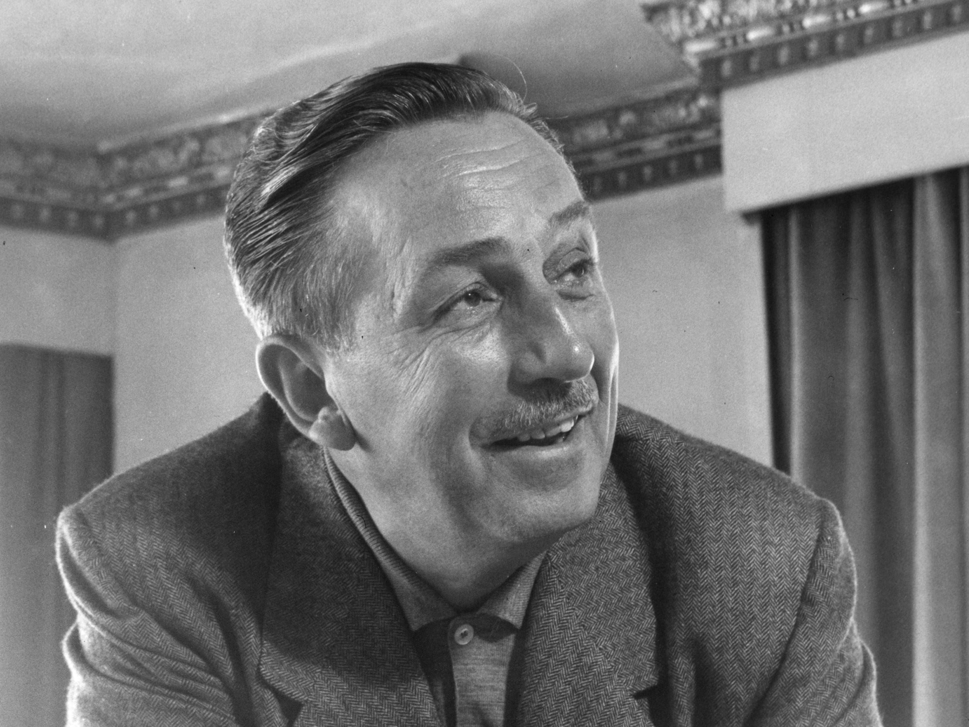 A close-up portrait of Walt Disney, in black and white.