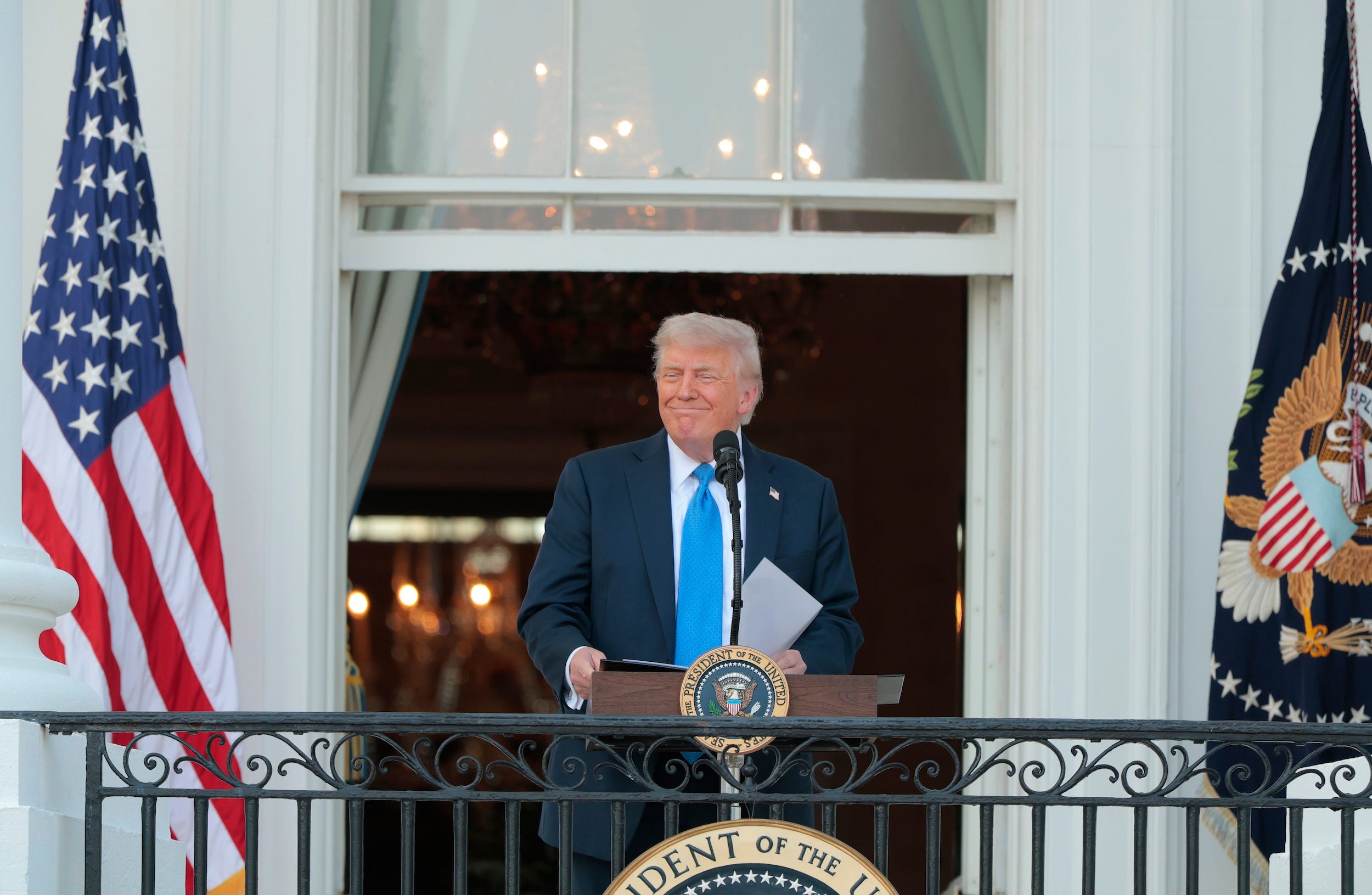 Donald Trump smiles while looking out at an event at the White House