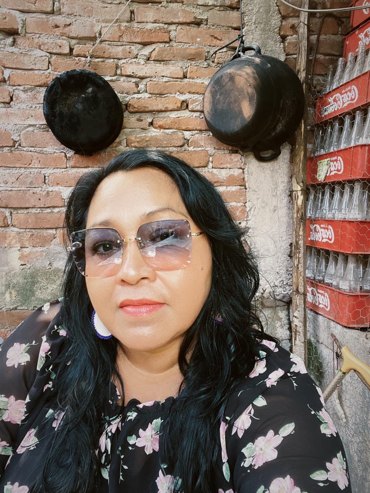 Regina Higuera wears a flower print shirt.