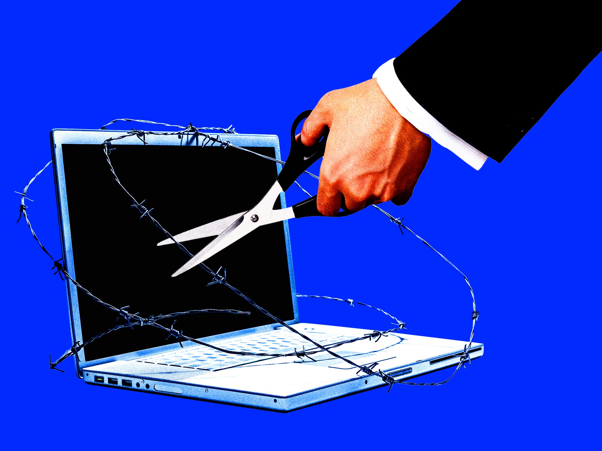 A businessman cutting barbed wire off a laptop
