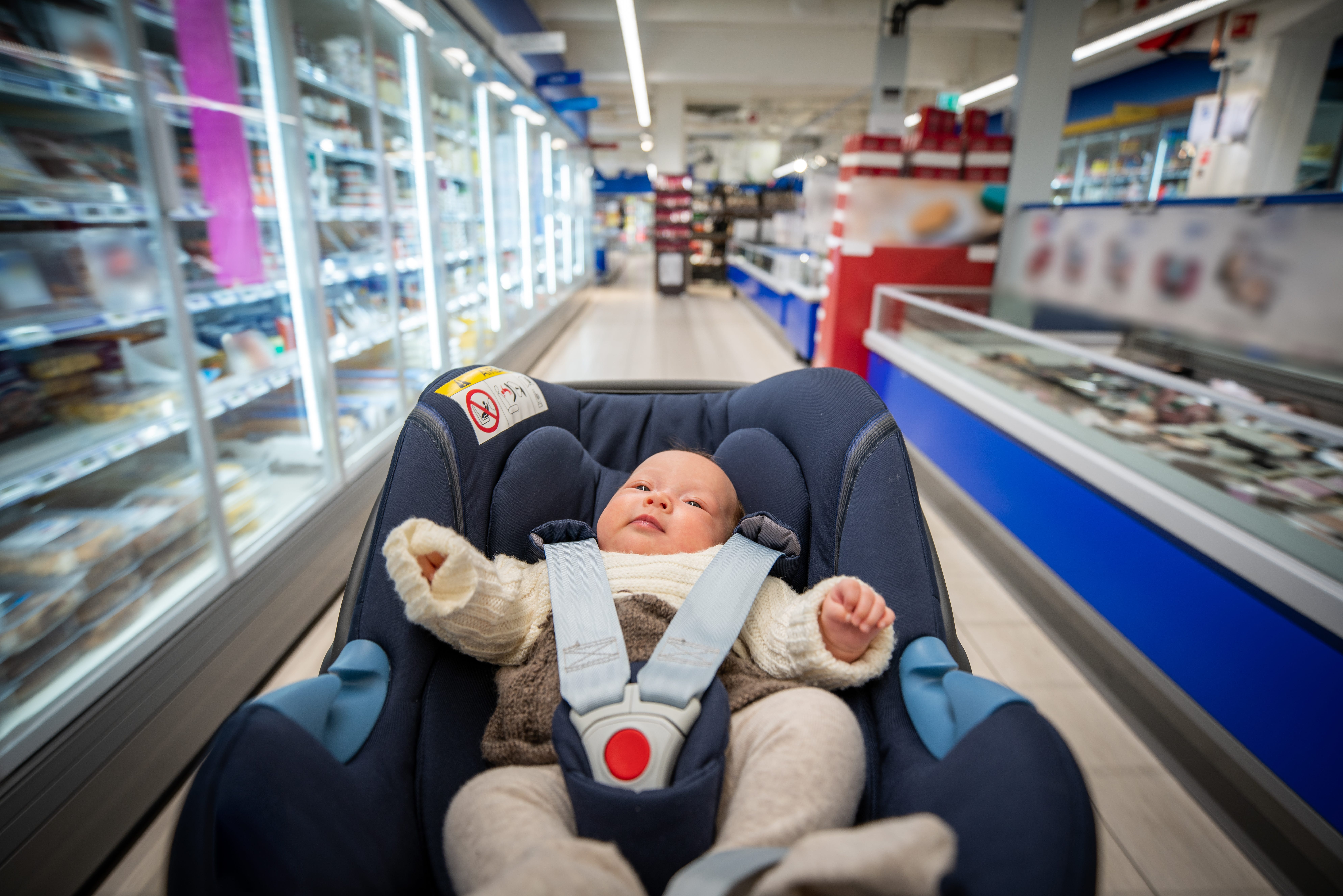 A baby photographed while sleeping in her stroller when out shopping at the mall.