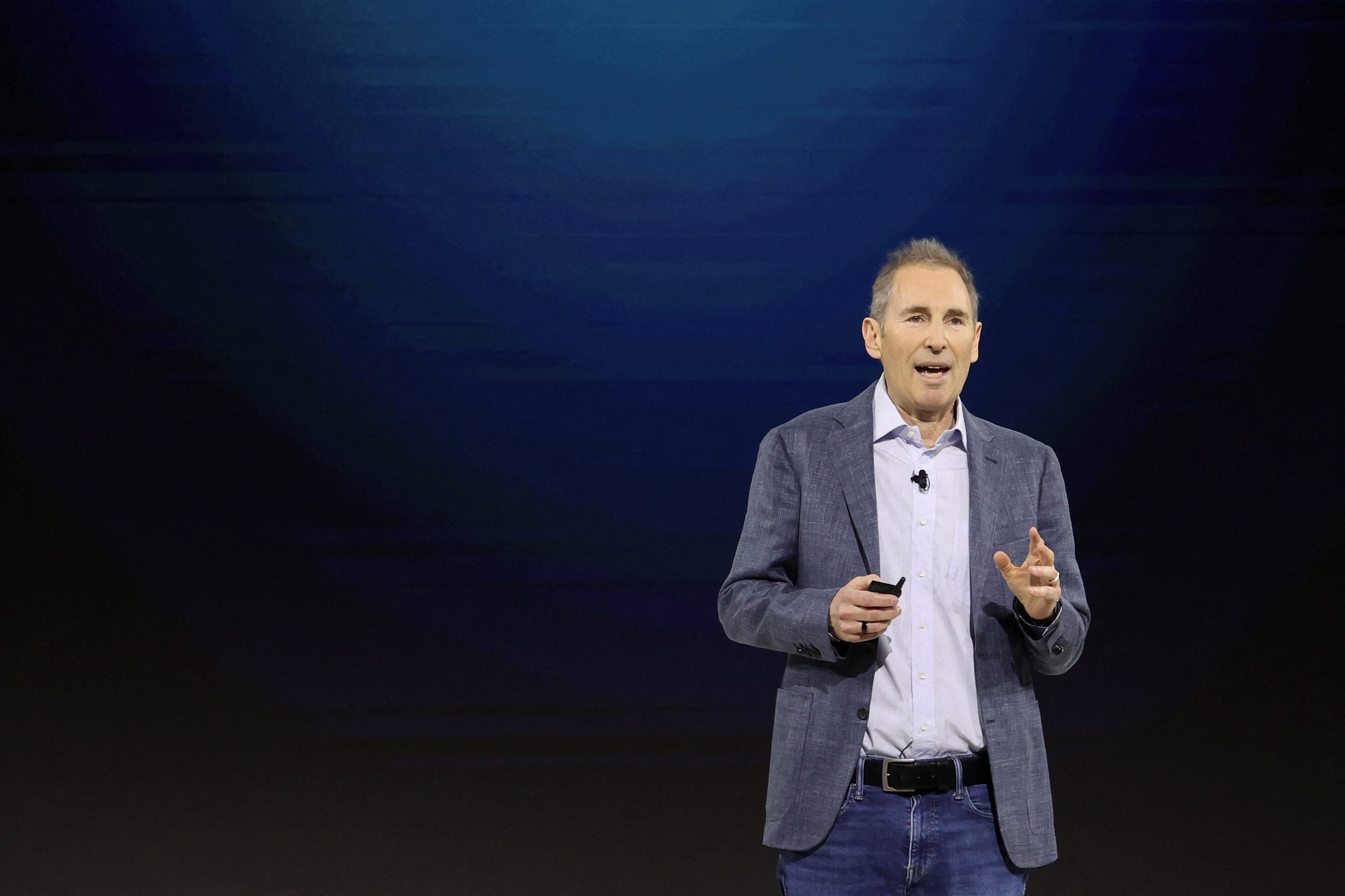 Andy Jassy giving a presentation with the words "Generative AI" on the screen behind him.