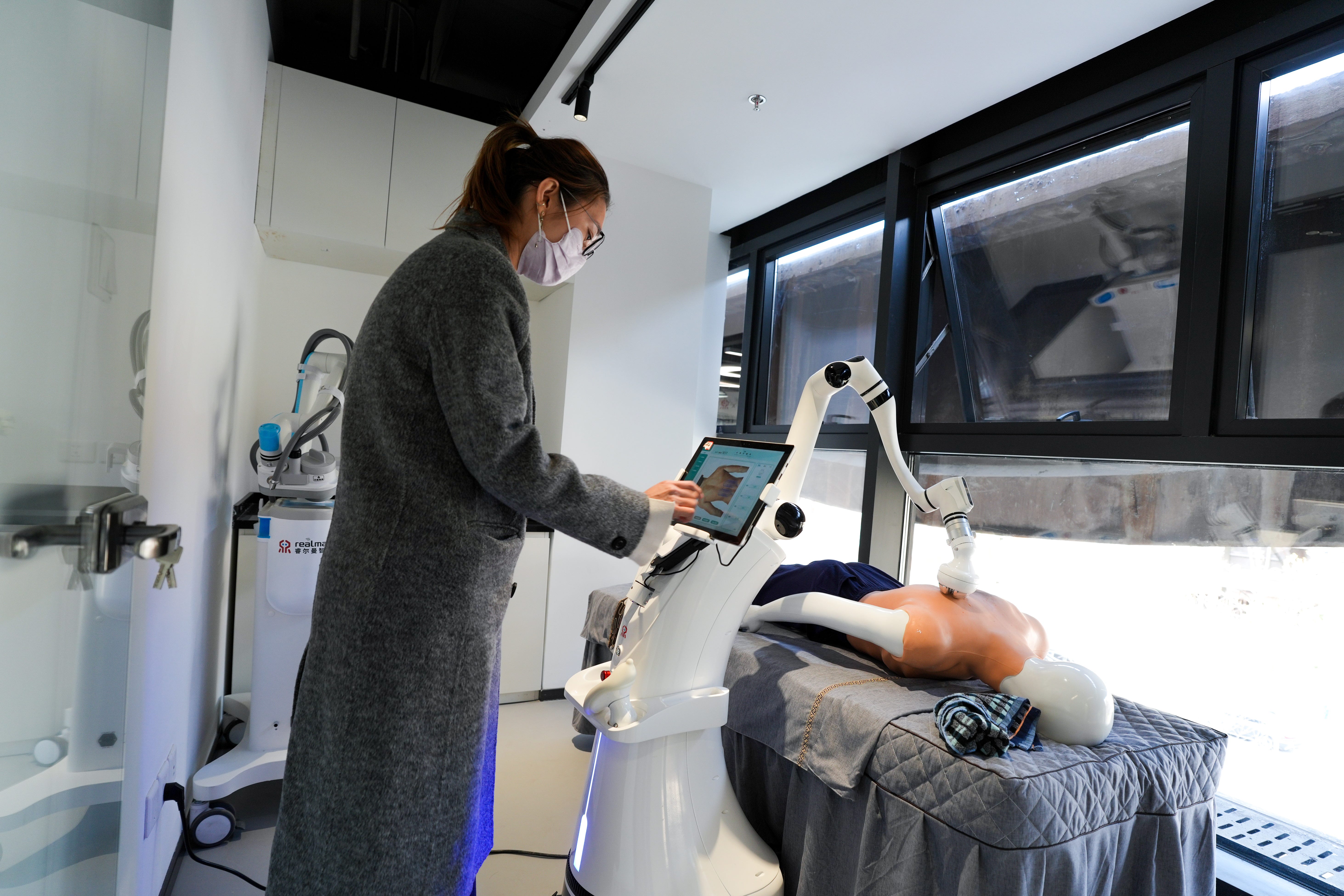 A worker trains a humanoid industrial robot at the humanoid robot data training center in Shougang Park in Beijing on March 27, 2025