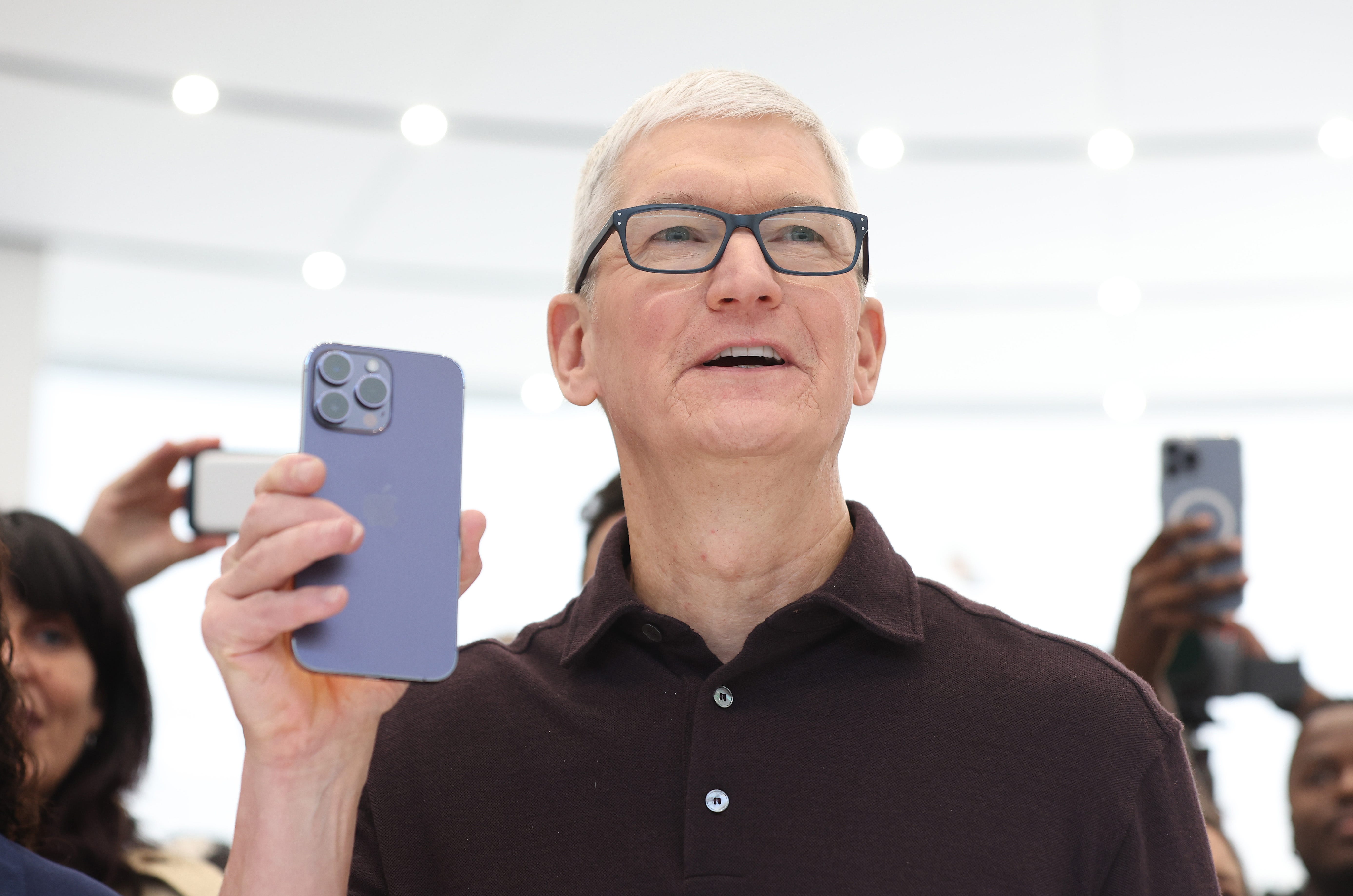 Apple CEO Tim Cook holding an iPhone