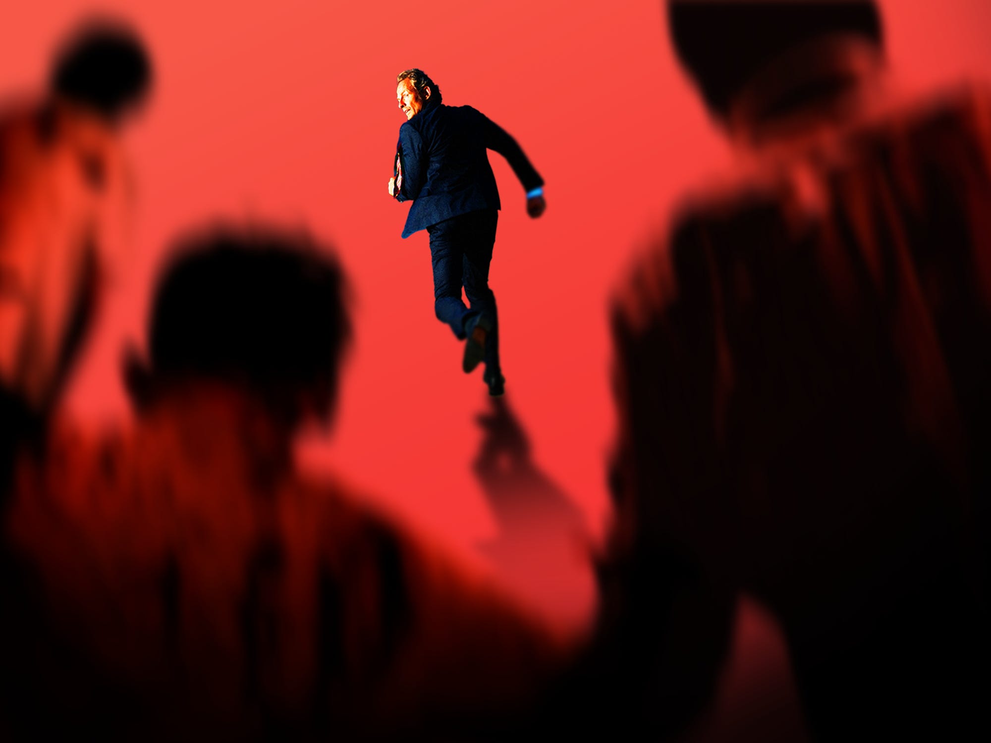 A business man running from a group of zombies