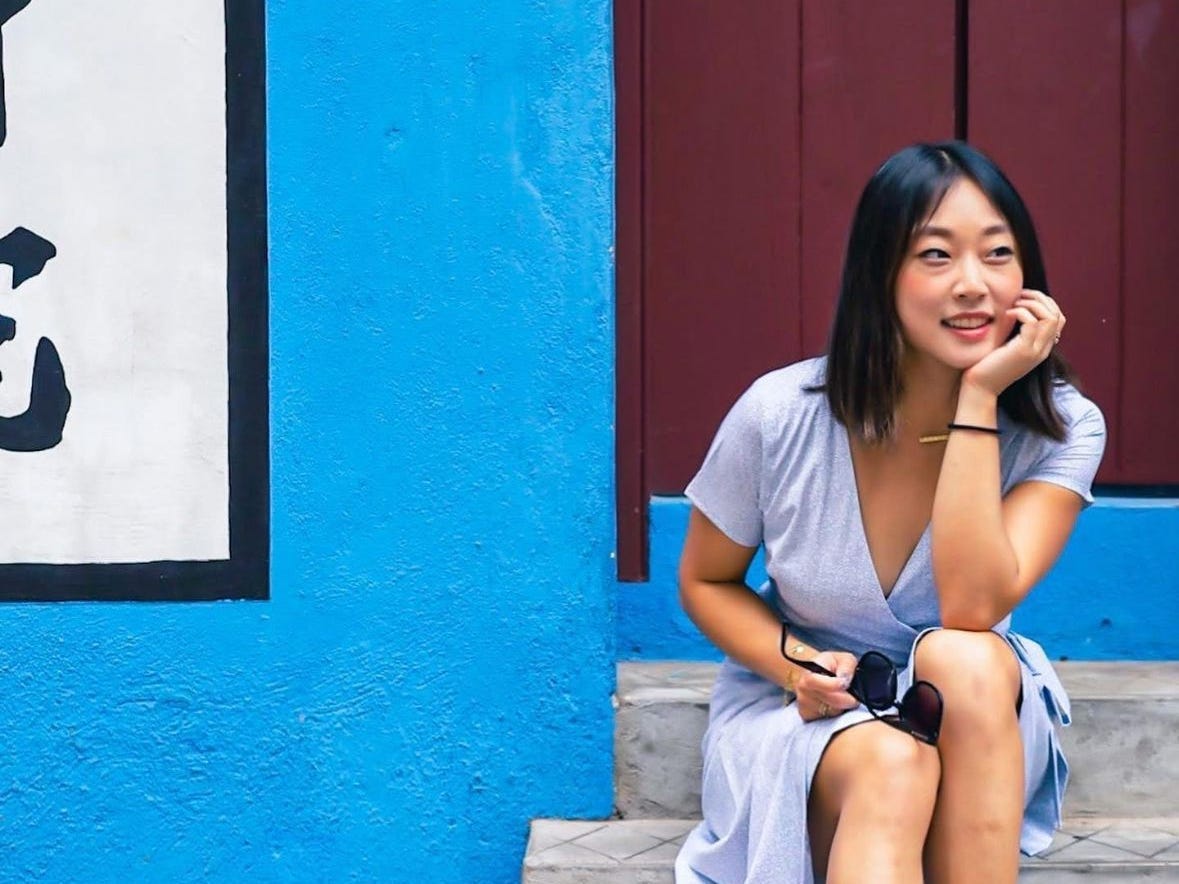 A woman sitting on blue stairs outside in Hong Kong.