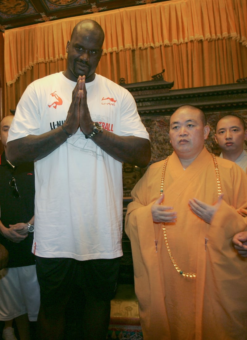 NBA team Cleveland Cavaliers' center Shaquille O'Neal (L) puts his palms together while meeting the Buddhist abbot Shi Yongxin at Shaolin Temple in Songshan, Henan province July 13, 2009. REUTERS/China Daily (CHINA SPORT BASKETBALL RELIGION) CHINA OUT. NO COMMERCIAL OR EDITORIAL SALES IN CHINA
