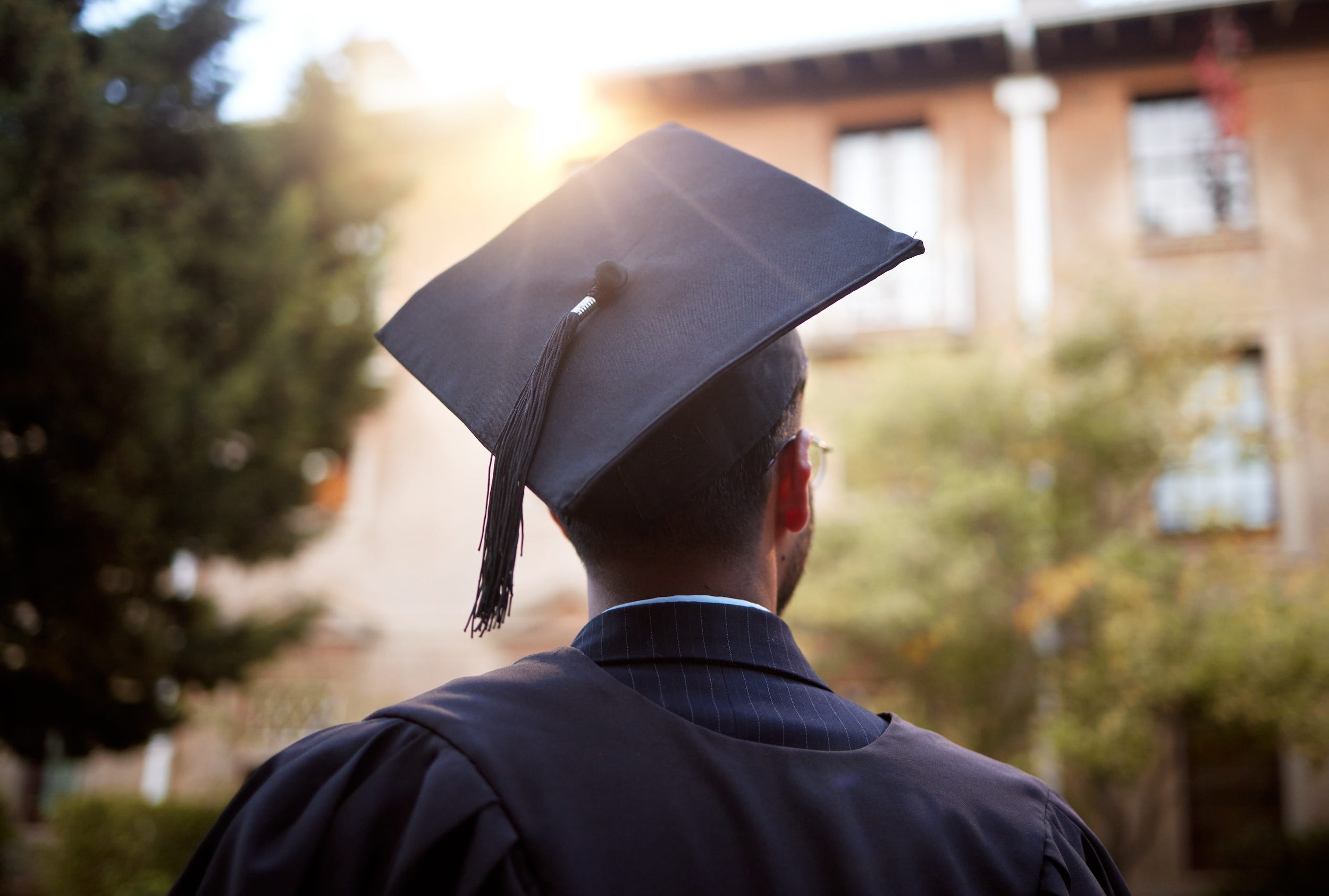 A college graduate with their back to the camera.