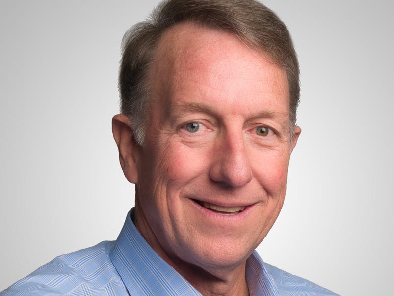 A headshot of David Specht, wearing a blue collared shirt.