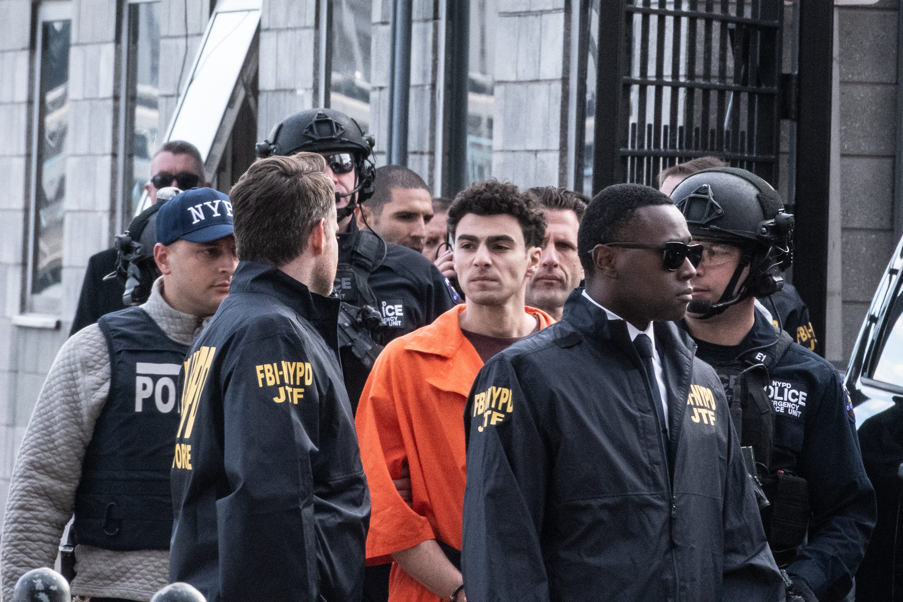 Luigi Mangione is shown being escorted by law enforcement after arriving in custody at a Manhattan heliport.