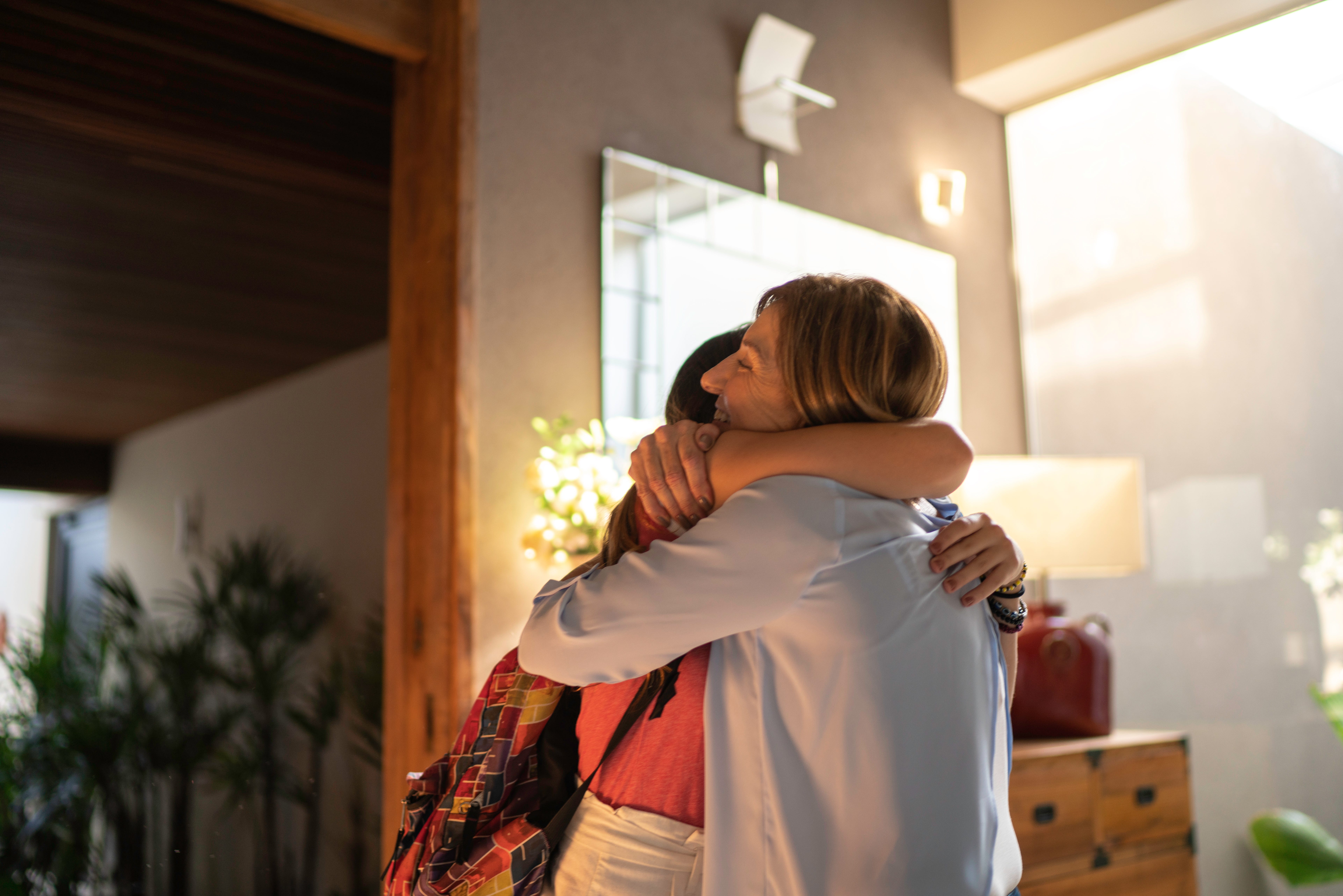 Mom hugging her college-age daughter.
