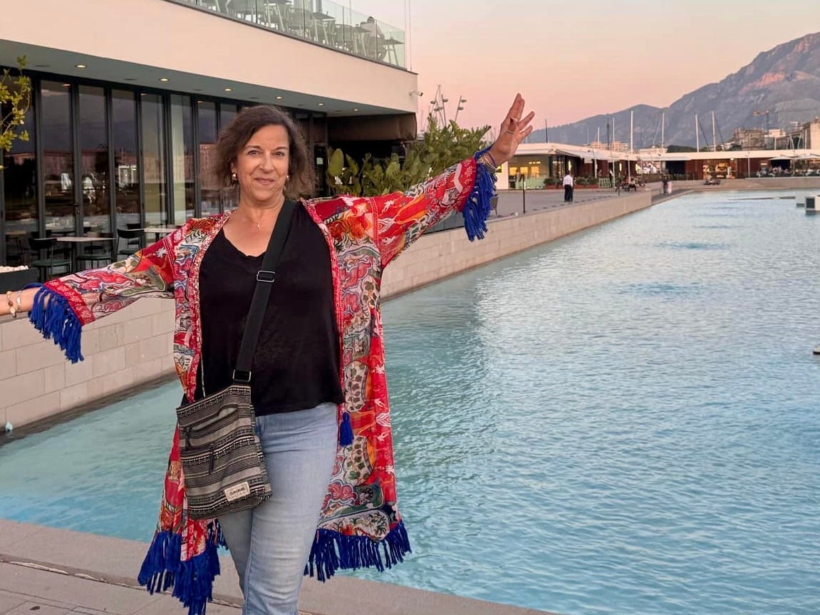 Cindy Sheahan, a woman, standing in front of a large body of water.