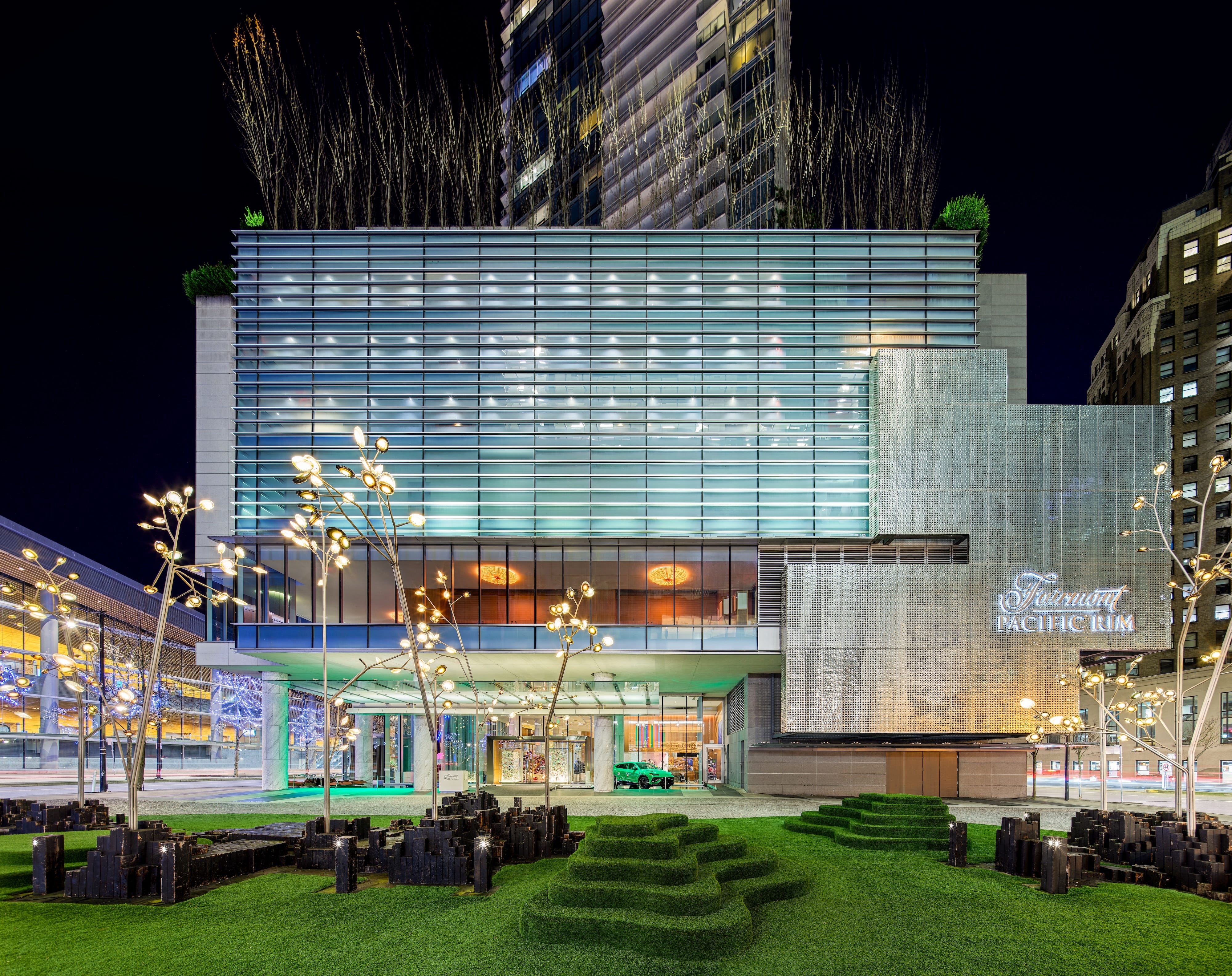 The exterior of the Fairmont Pacific Rim hotel in Vancouver, British Columbia, at night.