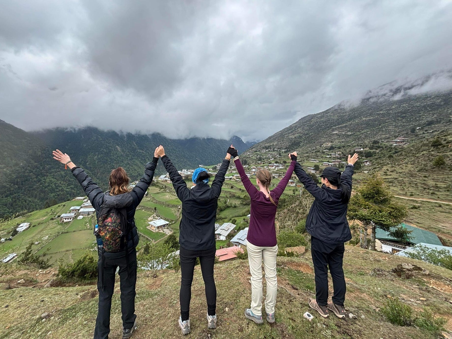 The author with her friends in Bhutan, hiking at the top of a mountain.