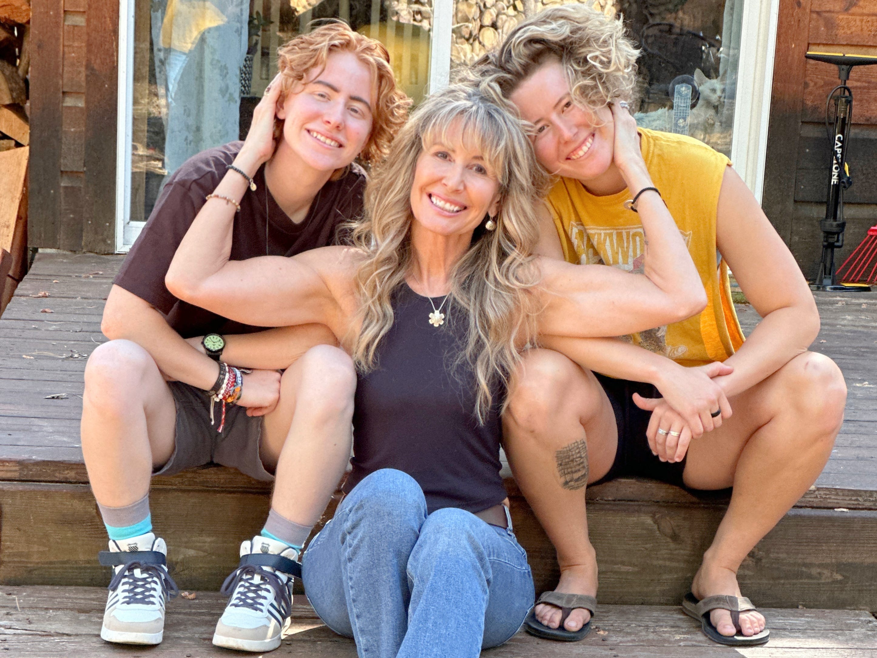 The author sitting with her two kids on a porch step.