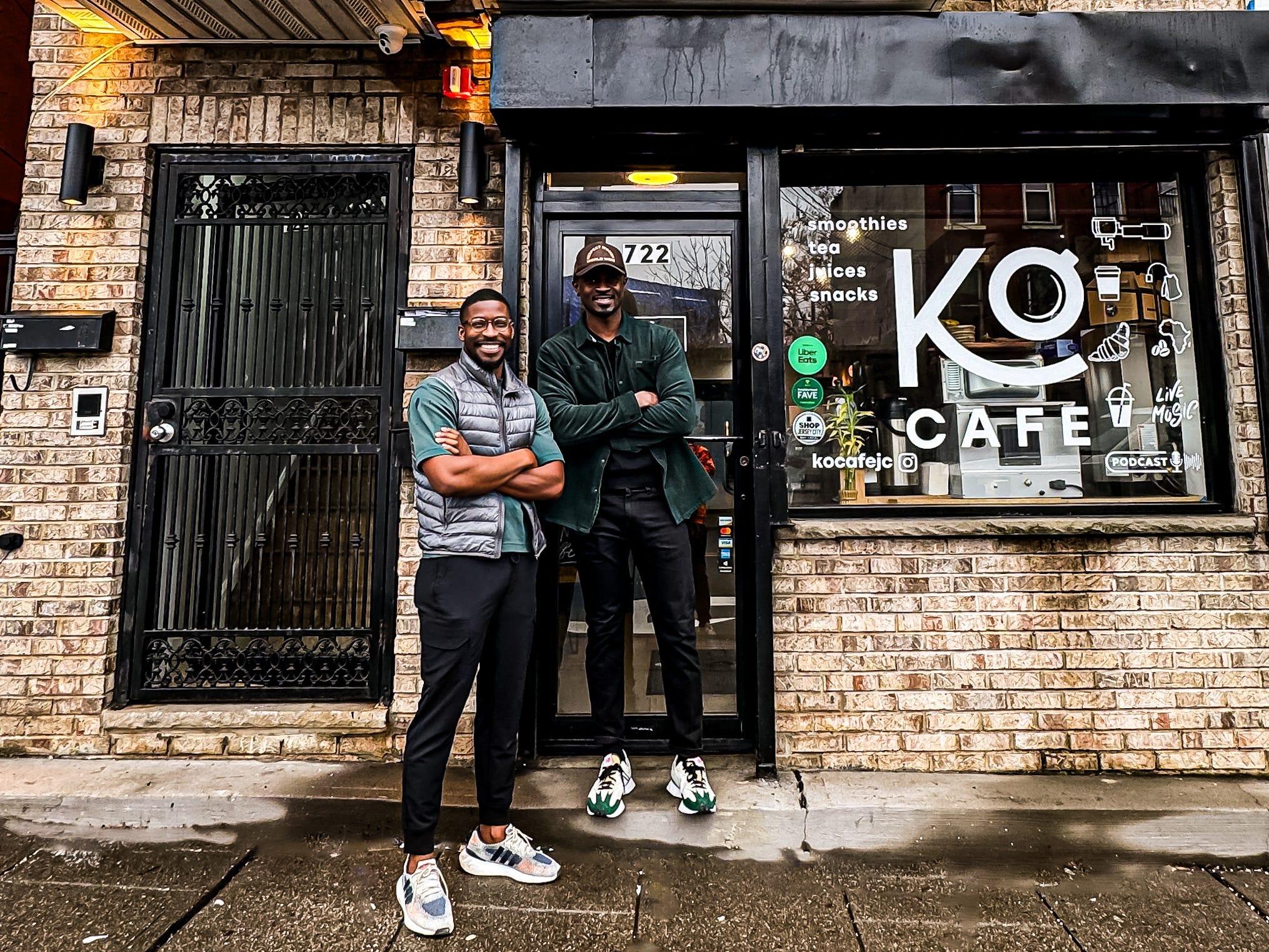 The owners of Ko cafe standing in front of the building.