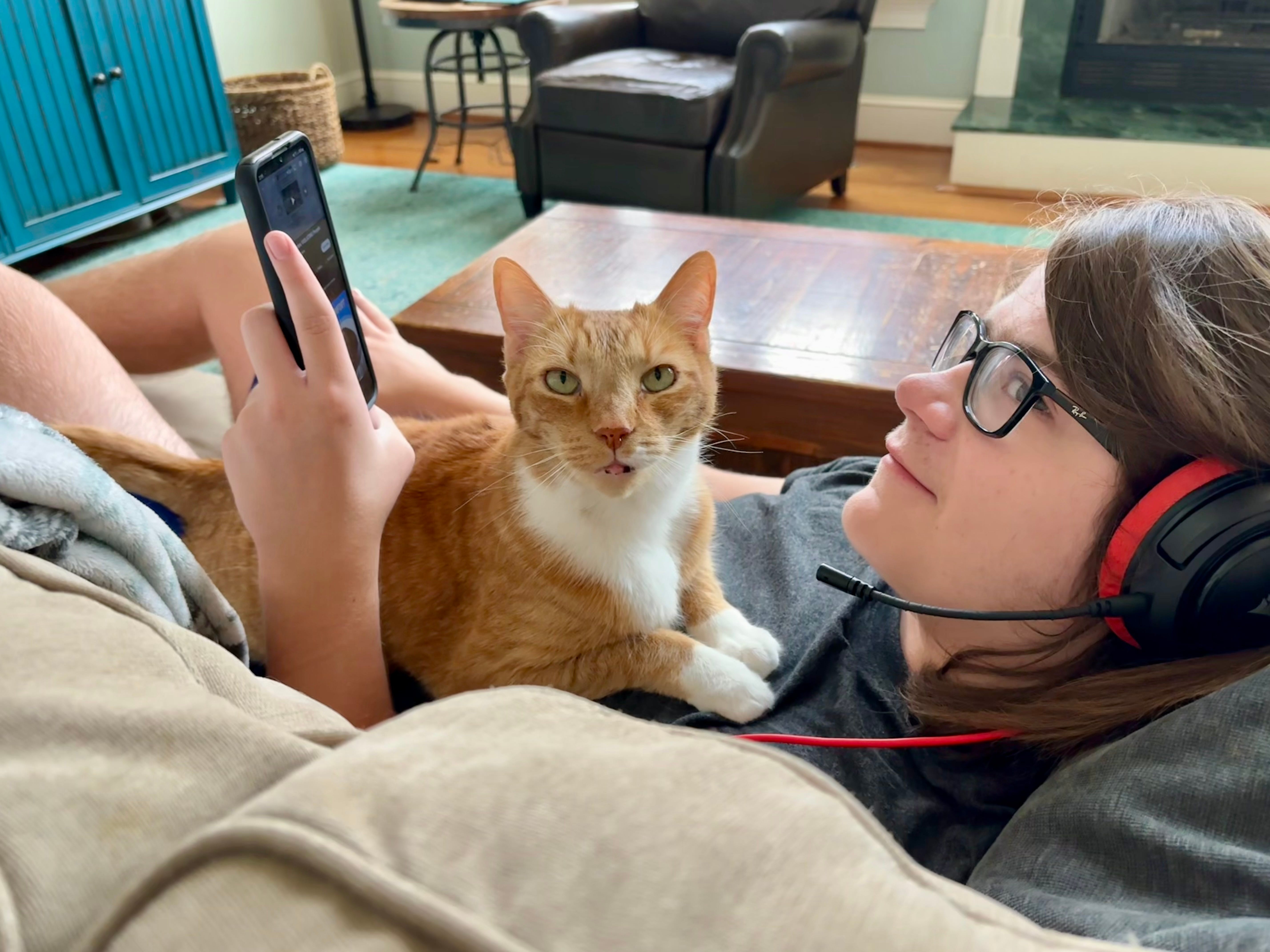 One of the author's kids lounging on the couch with their cat.