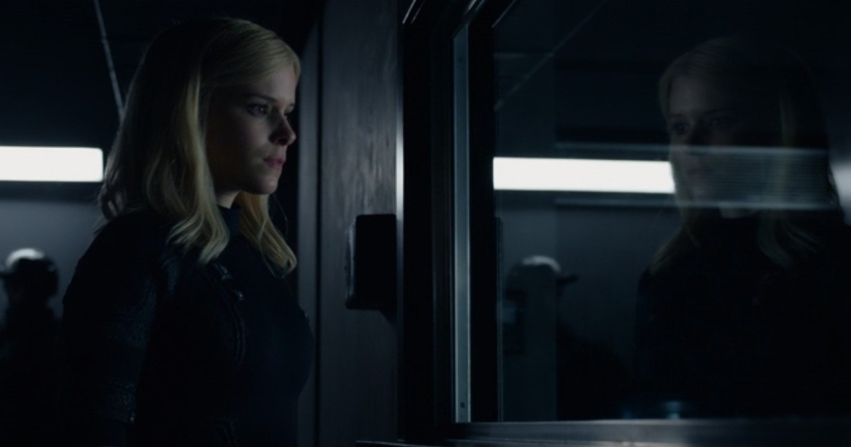 Sue Storm (Kate Mara) looks at her reflection in a military facility window in this scene from the 2015 Fantastic Four. 