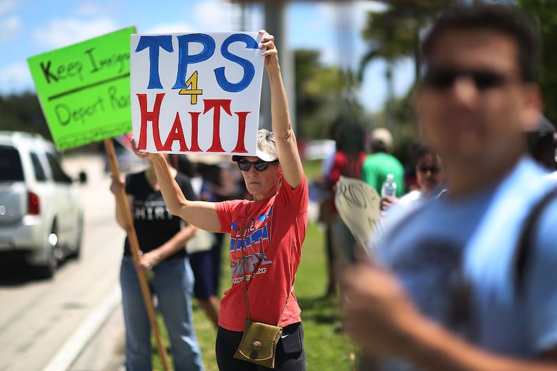 Protesters stamd in front of the United States Citizenship and Immigration Services office in Broward county to urge the Department of Homeland Security to extend Temporary Protected Status for Haitian immigrants on May 21, 2017 in Fort Lauderdale, Florida.