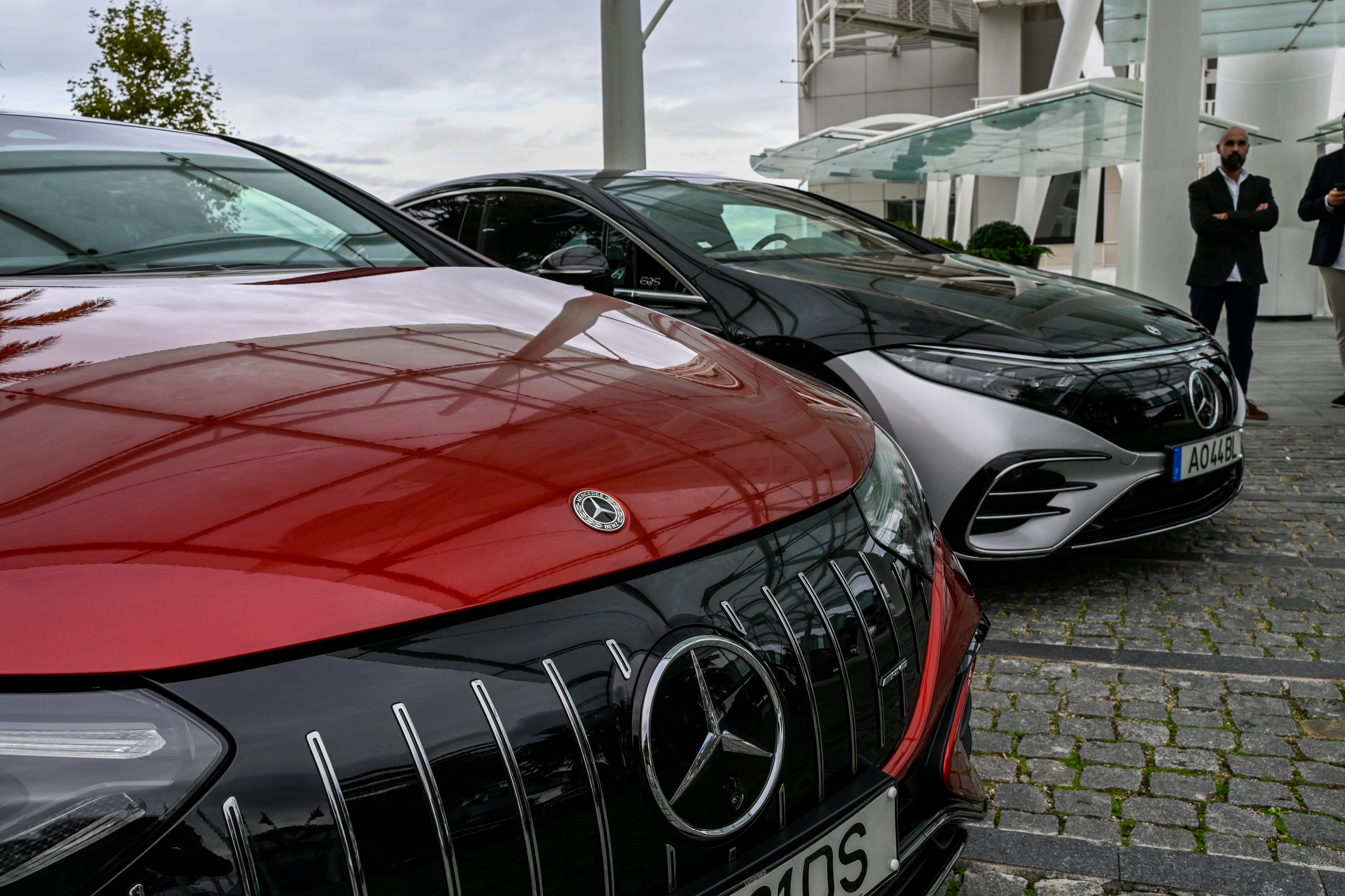 Two Mercedes electric cars are parked in a cobblestone driveway in Lisbon.