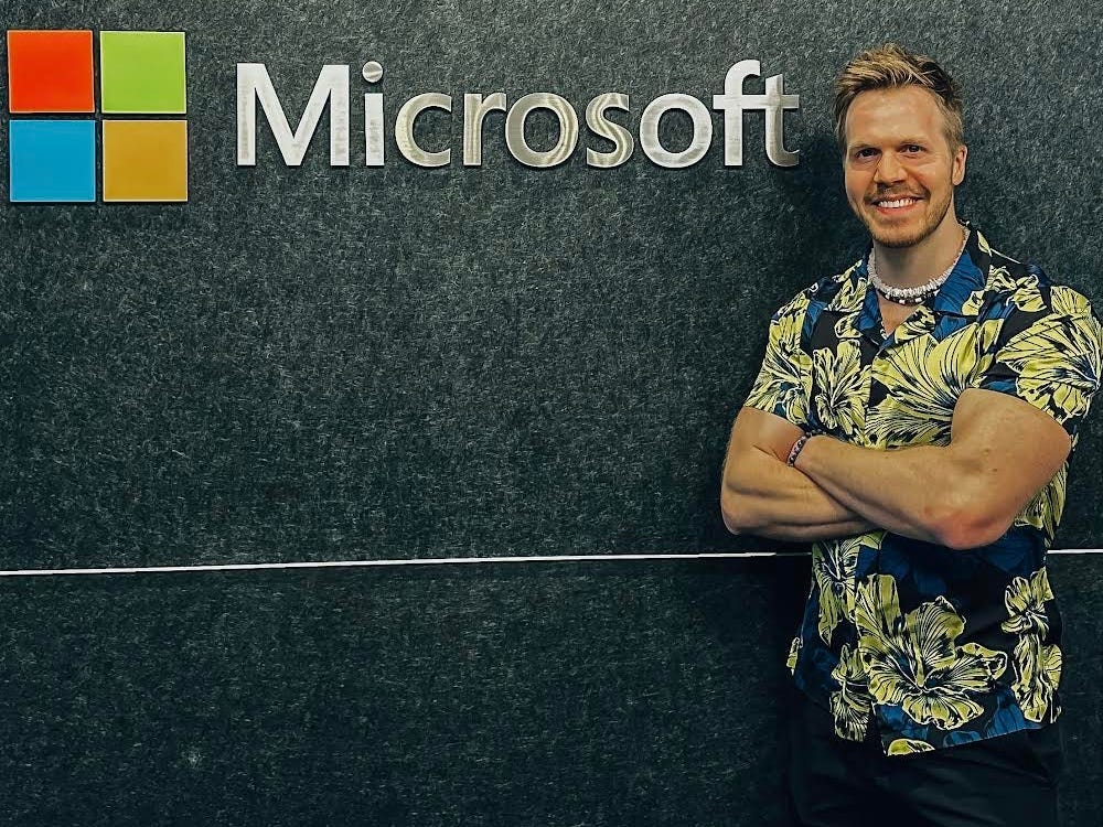 Patrick Lyons standing in front of office wall with Microsoft sign.