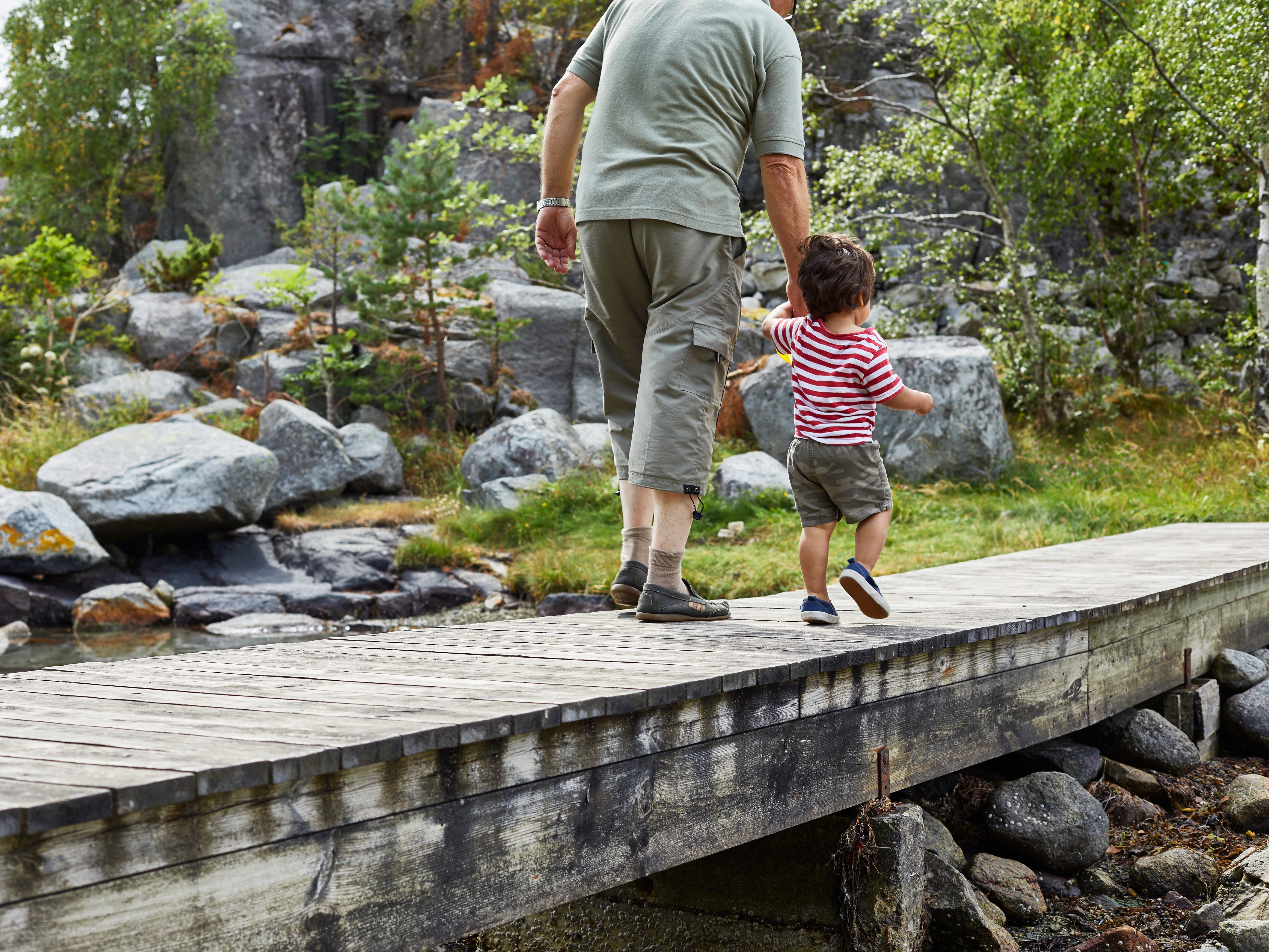 Dad and son walk on a deck bridge