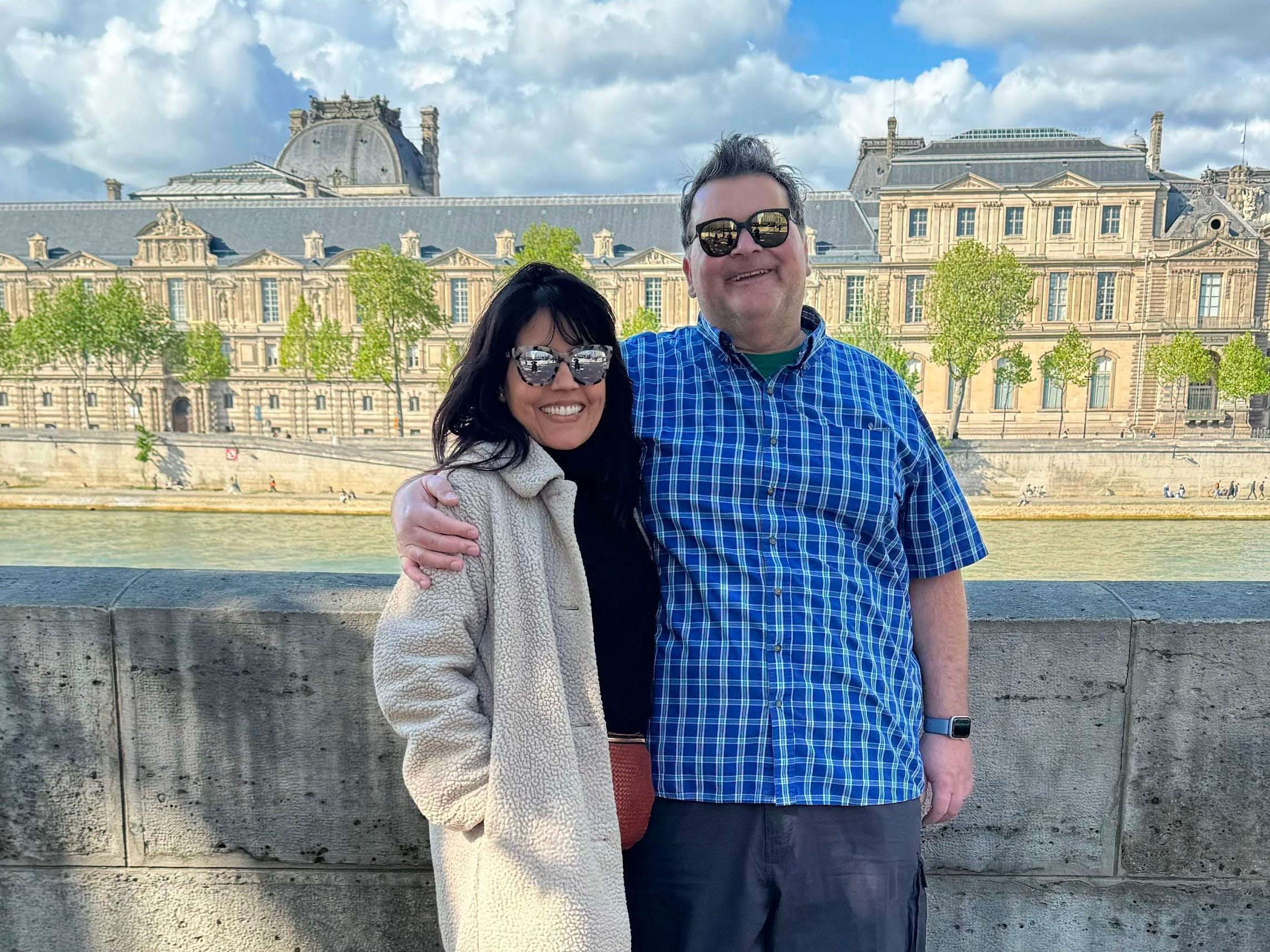 Author Mar Yvetteand her husband smiling in front of concrete ledge