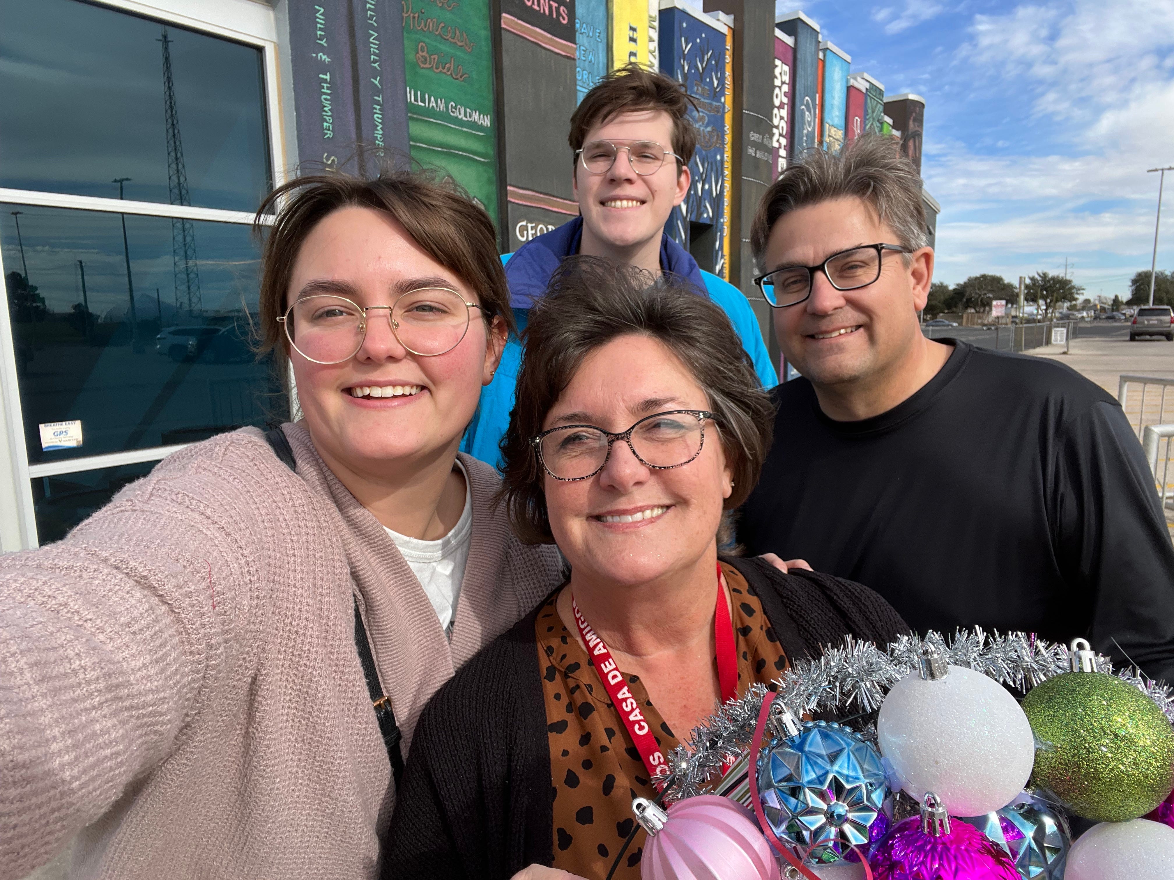 The author taking a selfie with her husband, mom, and dad.