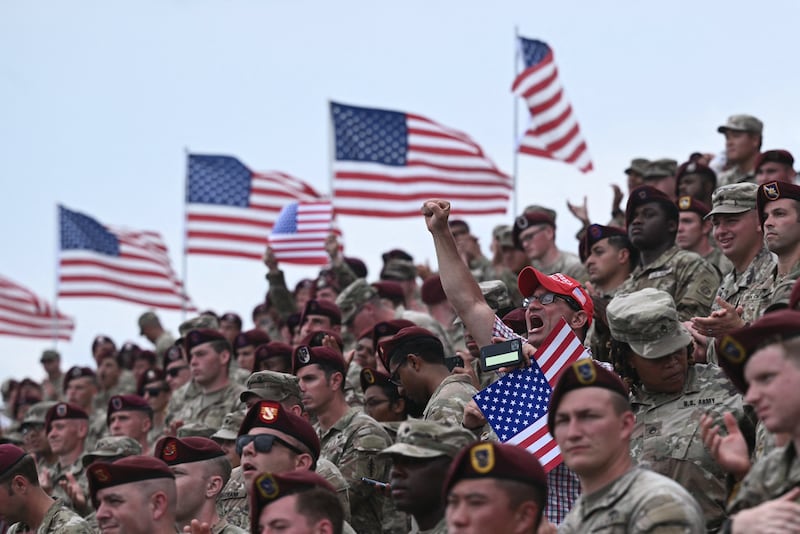 A man in a Make America Great Again hat cheers amid members of the U.S. army as the President Donald Trump speaks at Fort Bragg in Fayetteville, North Carolina, on June 10, 2025.