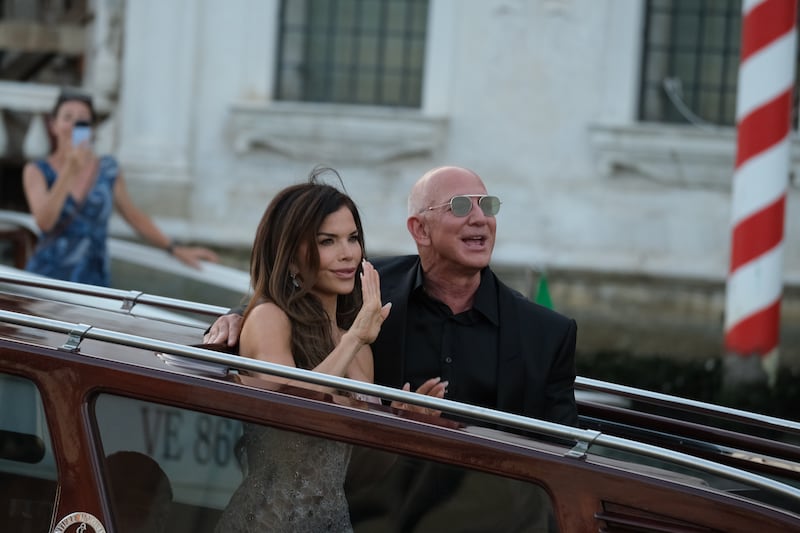 Lauren Sanchez and Jeff Bezos wave from a water taxi on June 28, 2025 while in Venice for their wedding.
