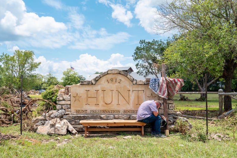 A man grieves at the entrance to the Hunt town square on July 9, 2025 in Hunt, Texas. Last Friday, heavy rainfall caused severe flash flooding throughout various cities along the Guadalupe River.