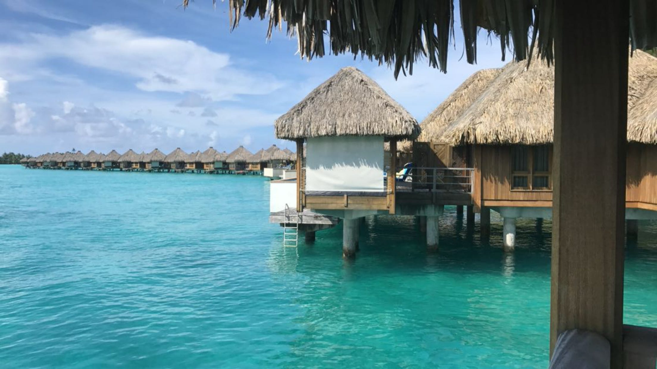 Overwater bungalows in turquoise waters in Bora Bora
