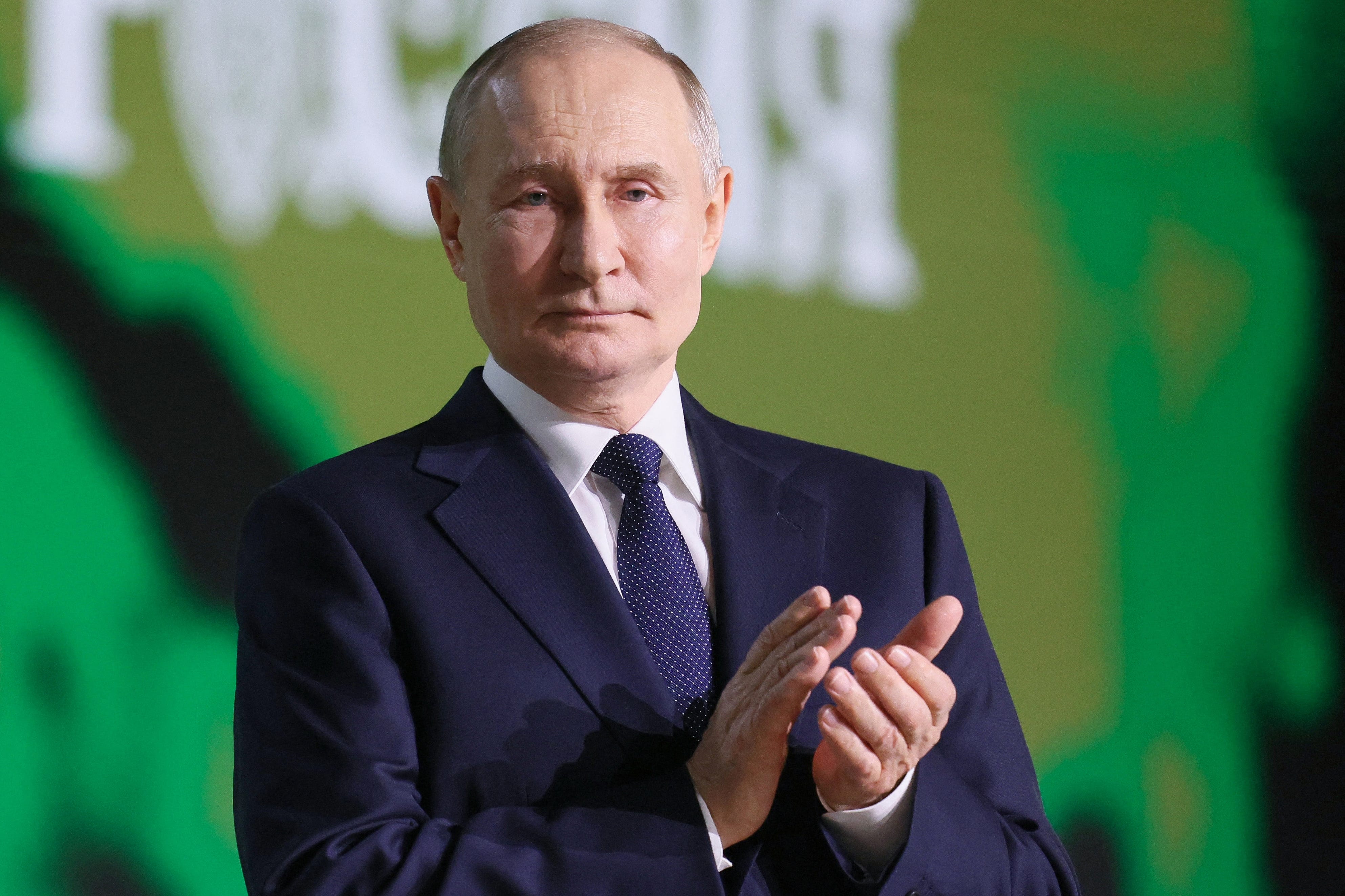 Russia's President Vladimir Putin applauds.