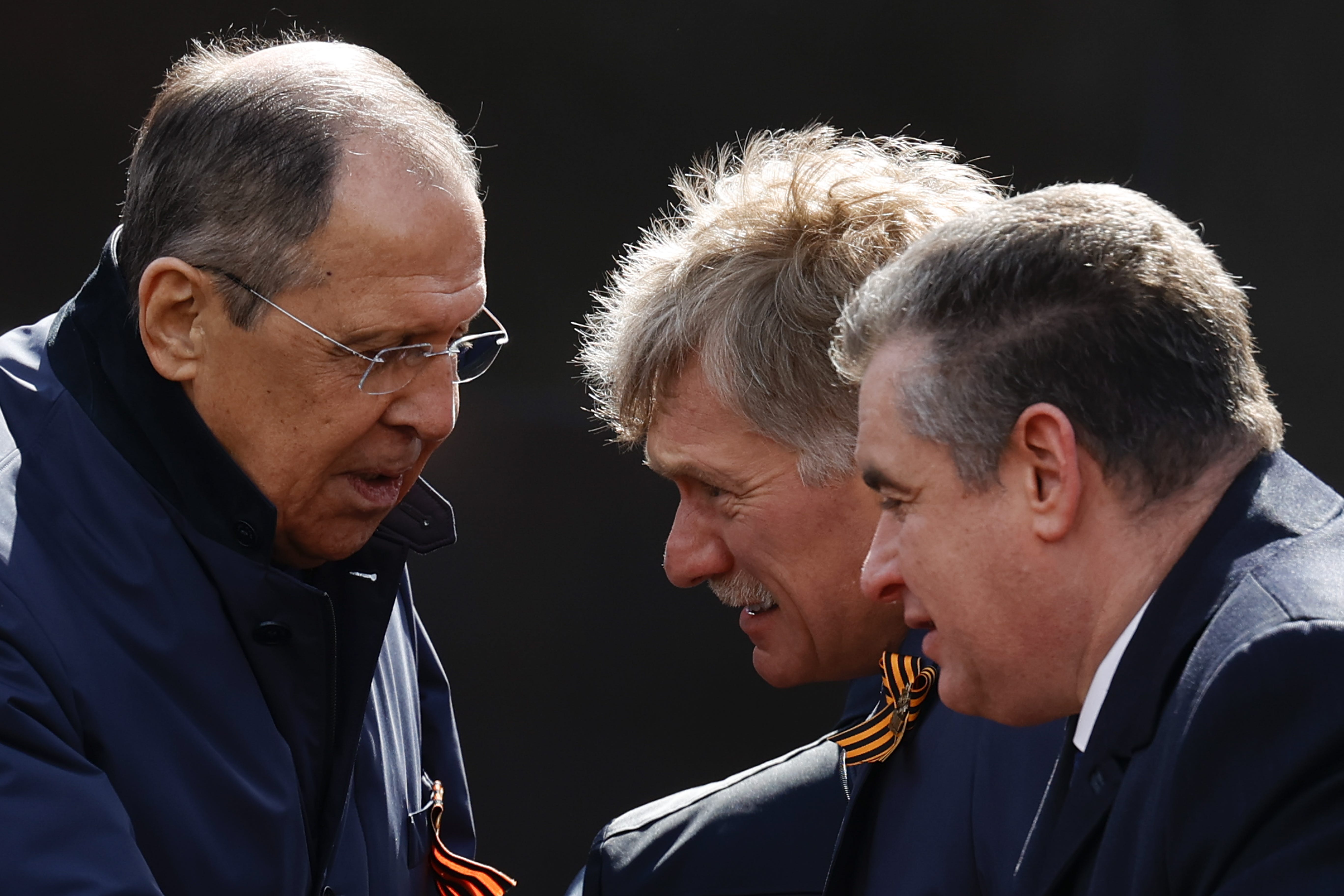 Sergey Lavrov and Kremlin spokesperson Dmitry Peskov lean in for a conversation.