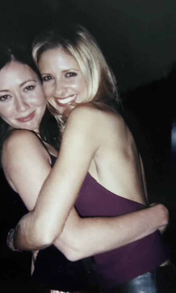 Shannen Doherty and Sarah Michelle Gellar hugging.