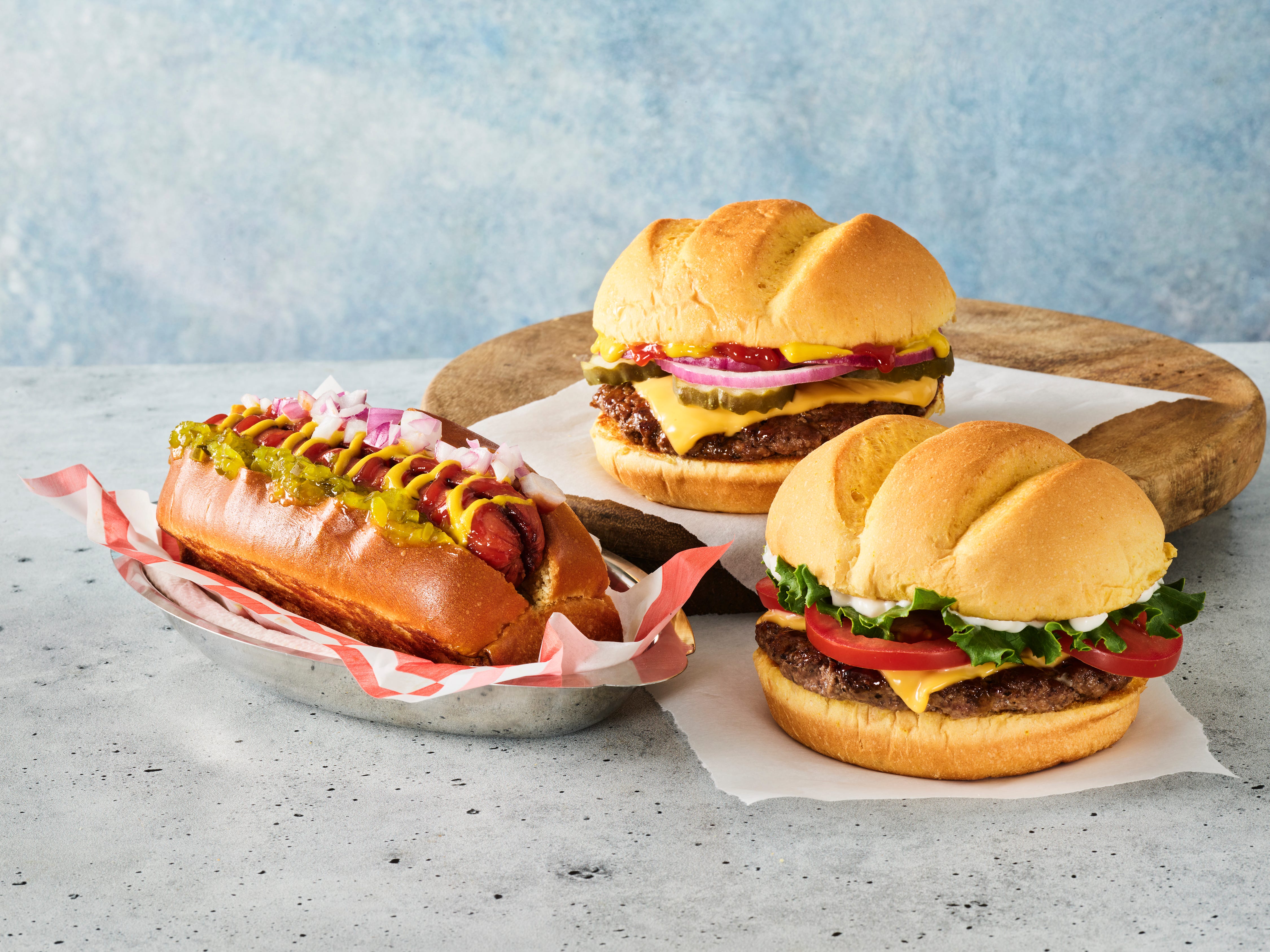 A plate of Smashburger menu items: two burgers and a new hot dog.