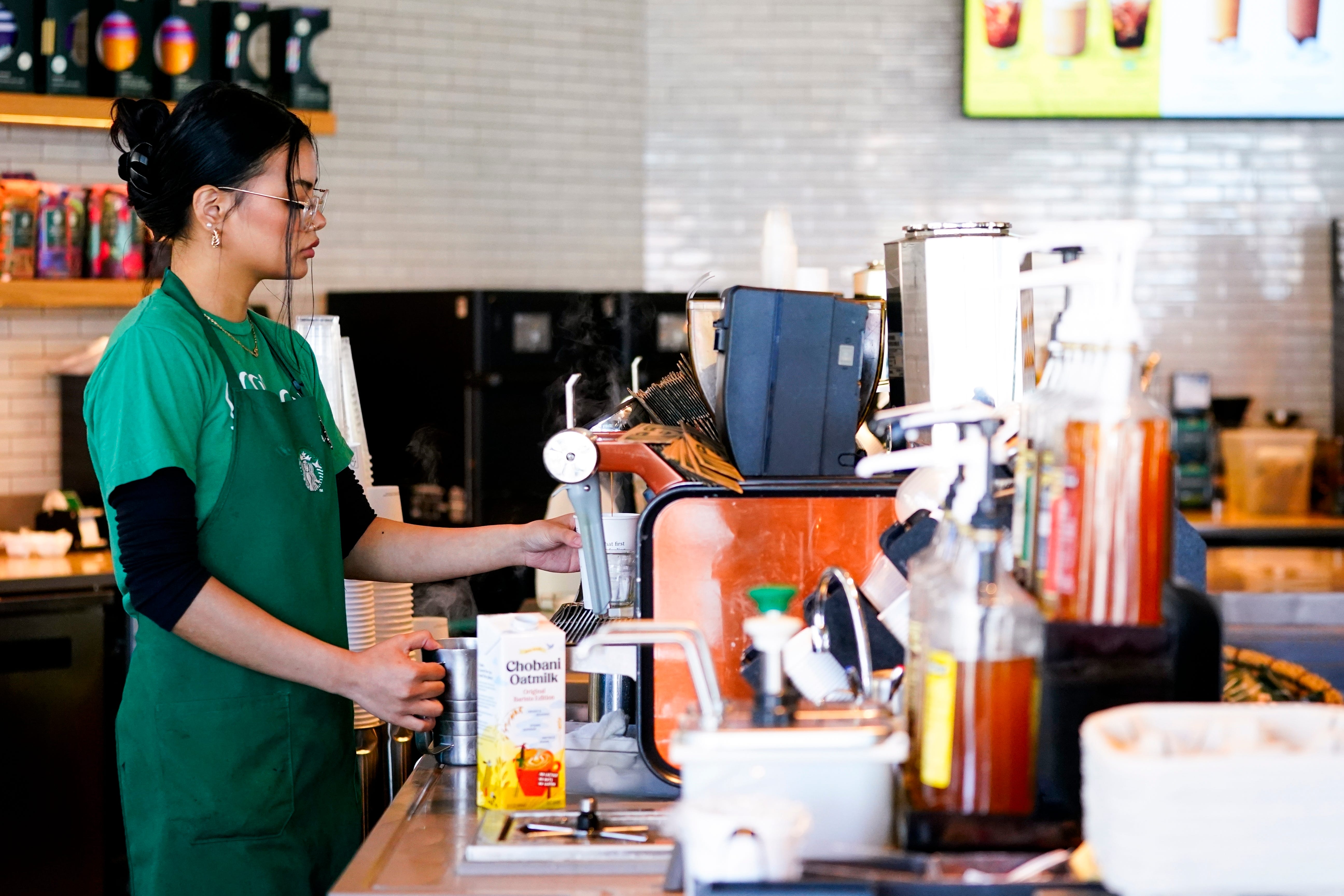A Starbucks barista working at an espresso machine.