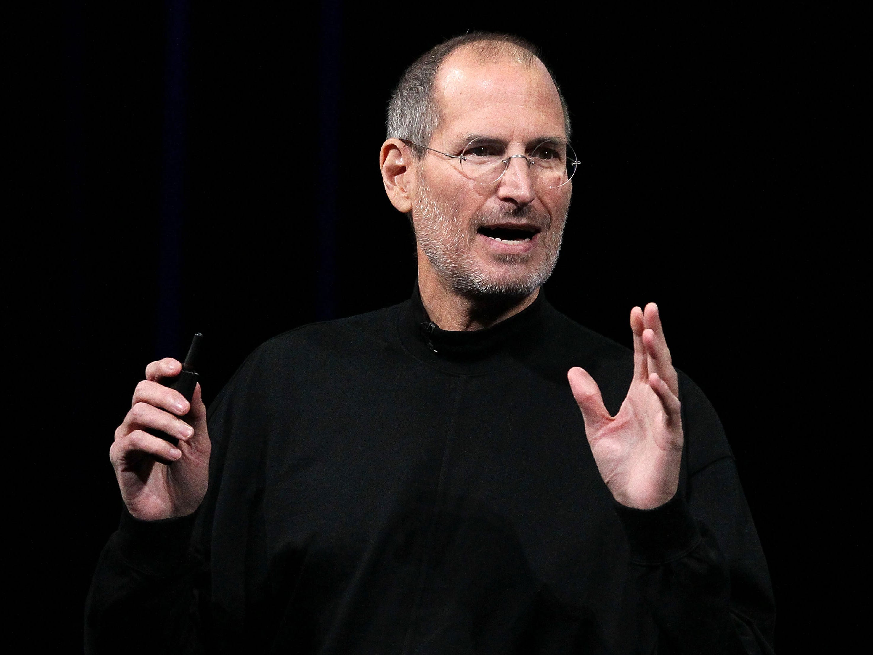 Apple cofounder Steve Jobs speaking with hands slightly raised